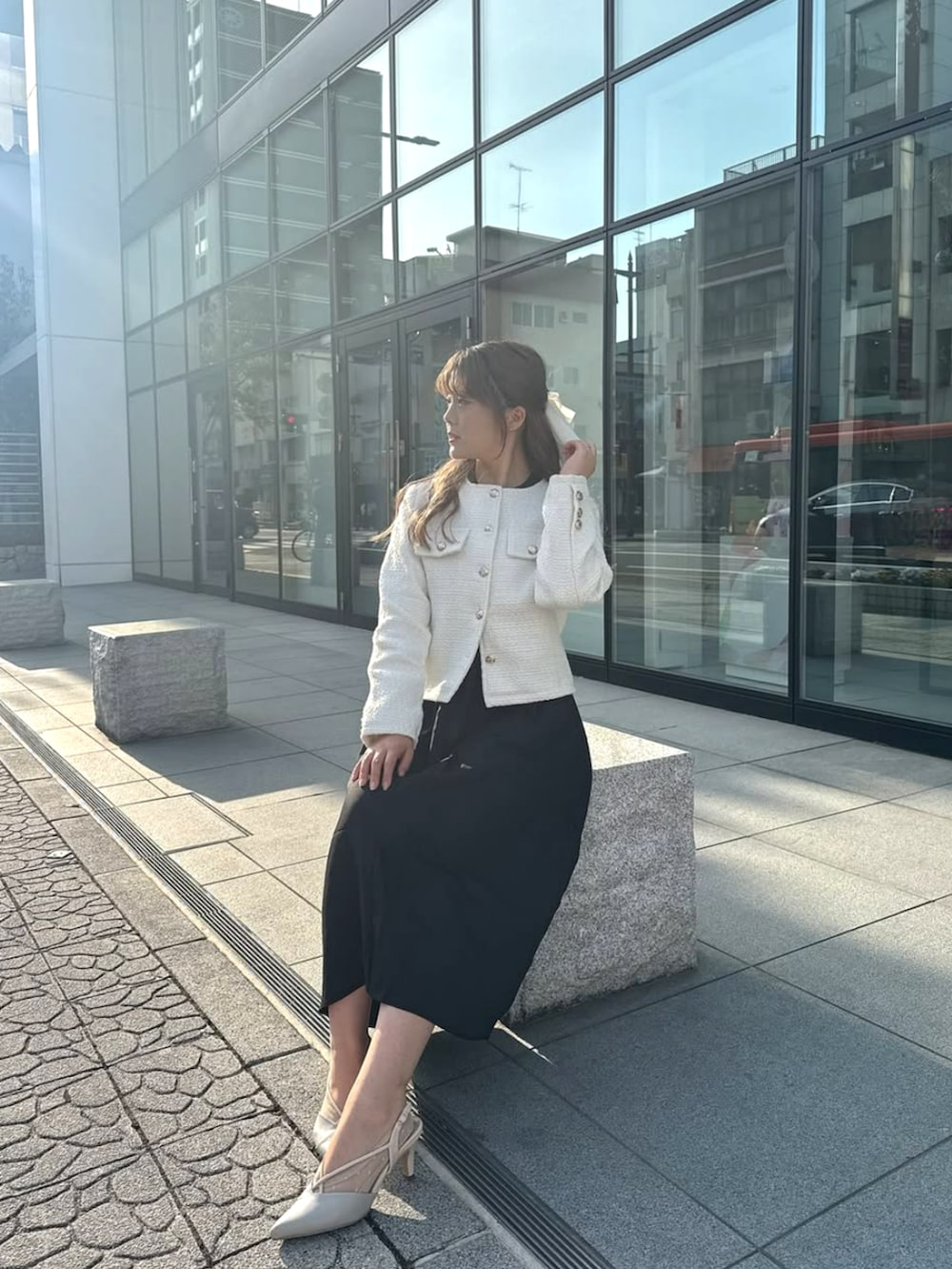 ホワイト系のノーカラージャケットを着用したレディースの冬コーディネートの2枚目の写真