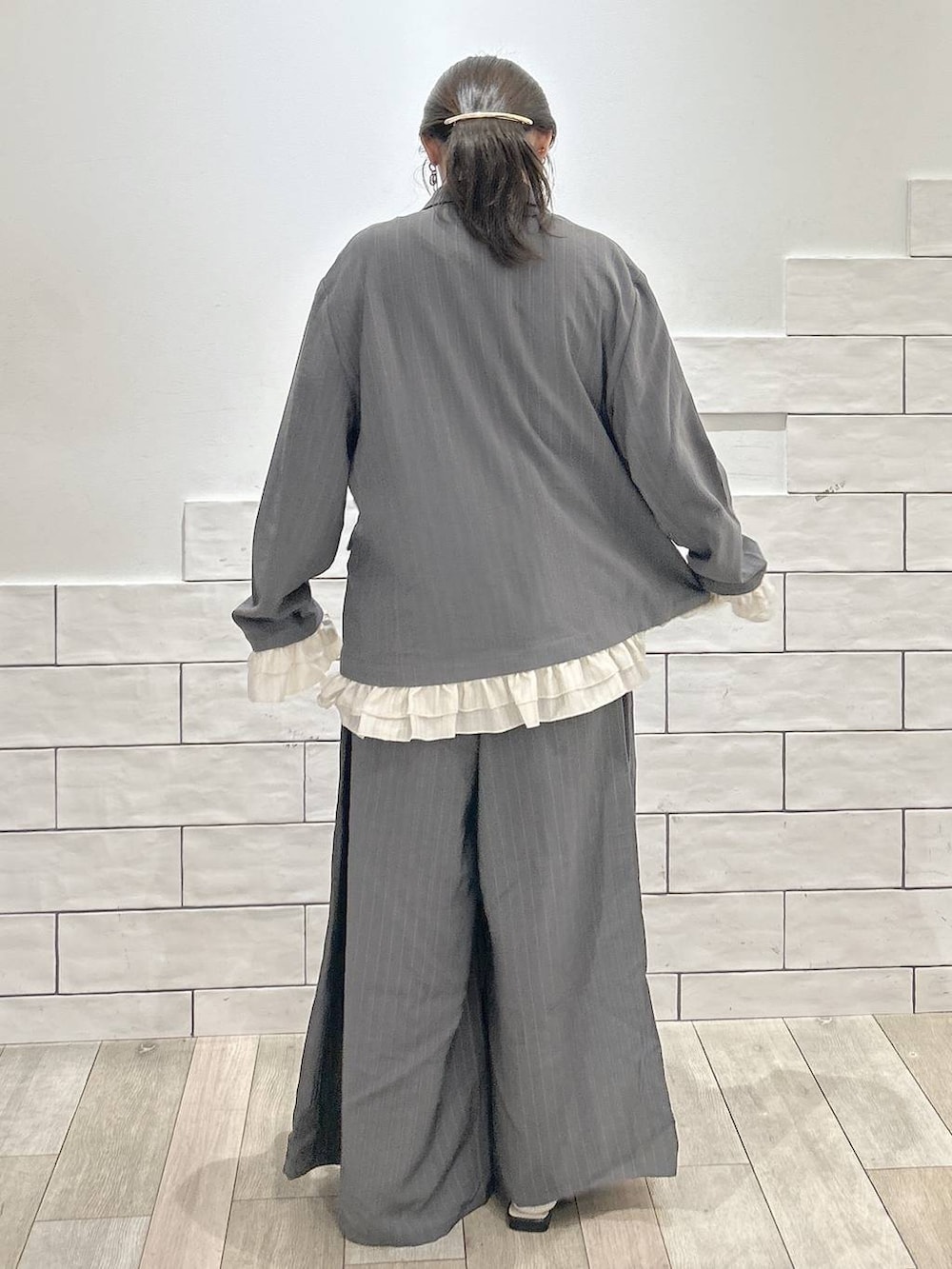 グレー系のその他パンツ、グレー系のテーラードジャケット、ブラック系のパンプスを着用したレディースの春コーディネートの4枚目の写真