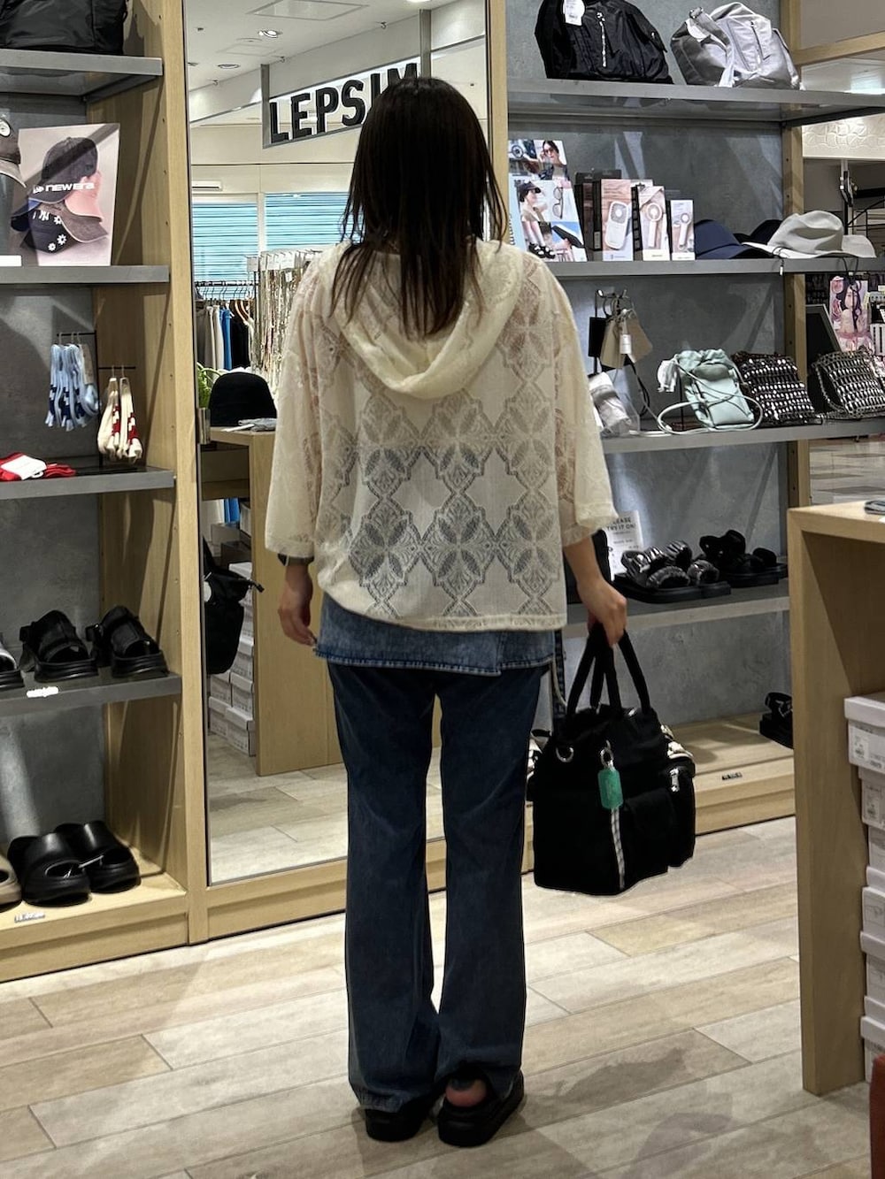 ブラック系のトートバッグ、ブラック系のサンダル、ホワイト系のシャツ/ブラウスを着用したレディースの夏コーディネートの3枚目の写真