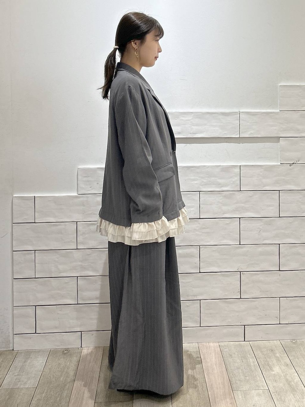 グレー系のその他パンツ、グレー系のテーラードジャケット、ブラック系のパンプスを着用したレディースの春コーディネートの2枚目の写真