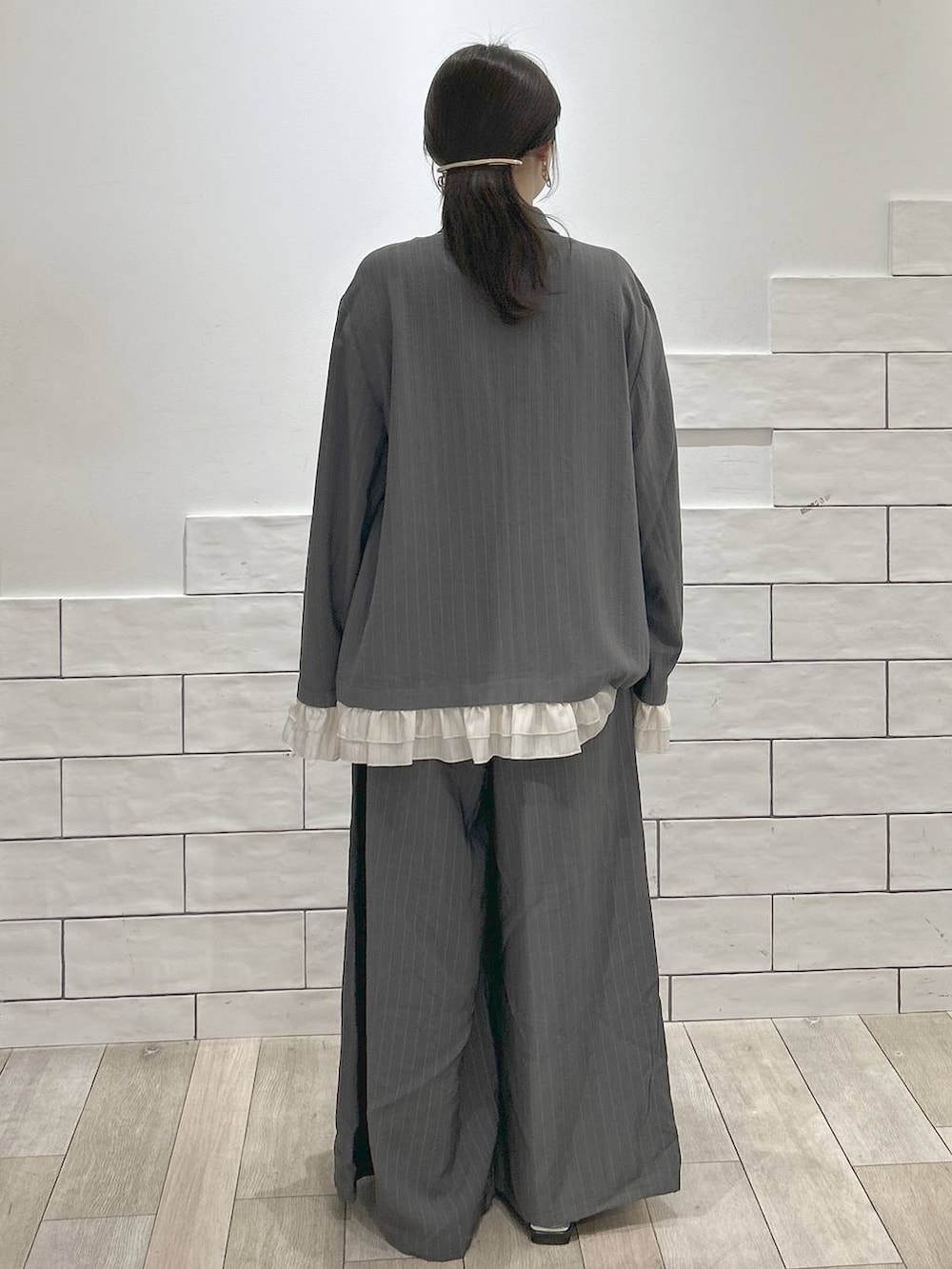 グレー系のその他パンツ、グレー系のテーラードジャケット、ブラック系のパンプスを着用したレディースの春コーディネートの3枚目の写真