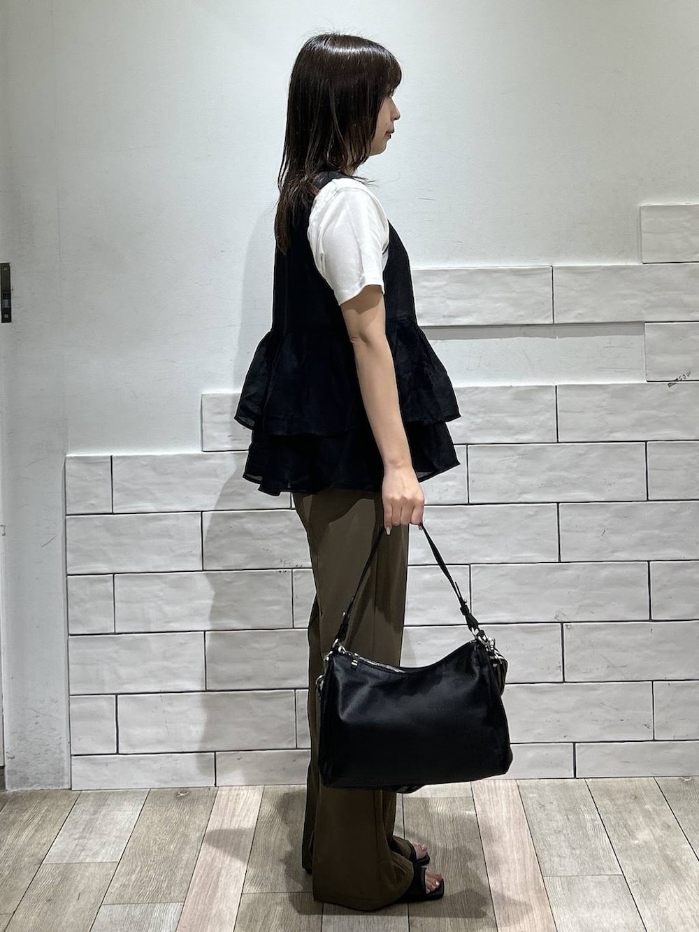 ブラック系のサンダル、ホワイト系のTシャツ/カットソー、ブラウン系のその他パンツを着用したレディースの夏コーディネートの2枚目の写真