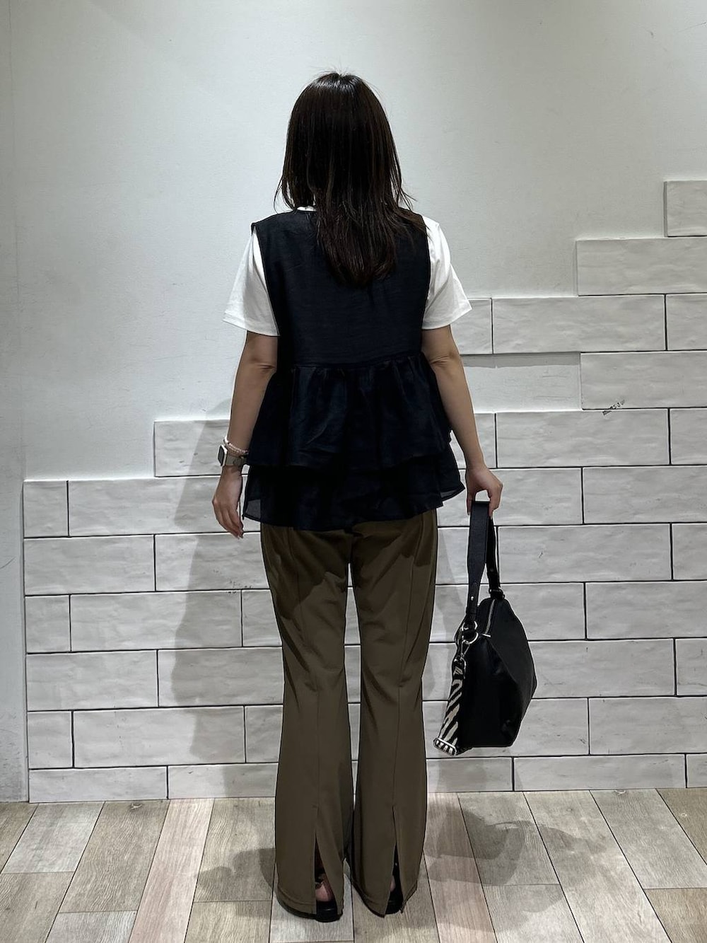 ブラック系のサンダル、ホワイト系のTシャツ/カットソー、ブラウン系のその他パンツを着用したレディースの夏コーディネートの3枚目の写真