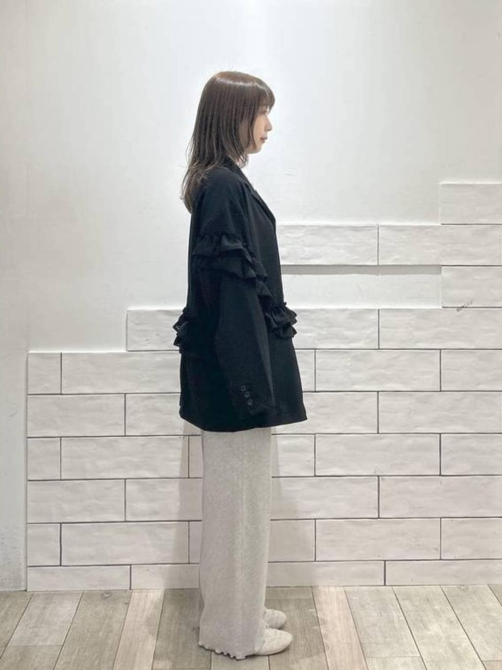 ホワイト系のTシャツ/カットソー、ブラック系のテーラードジャケット、グレー系のその他パンツを着用したレディースの冬コーディネートの2枚目の写真