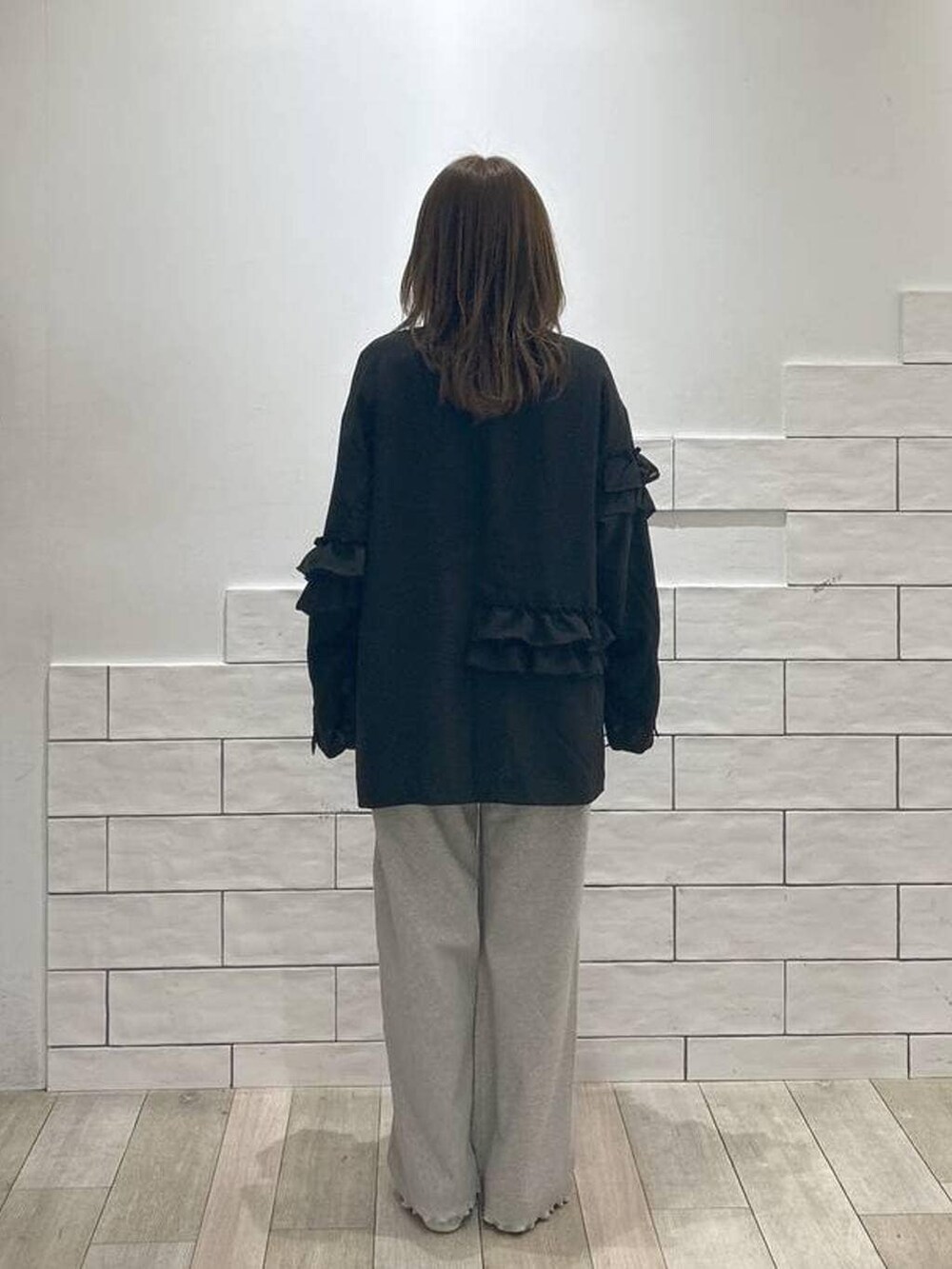 ホワイト系のTシャツ/カットソー、ブラック系のテーラードジャケット、グレー系のその他パンツを着用したレディースの冬コーディネートの3枚目の写真