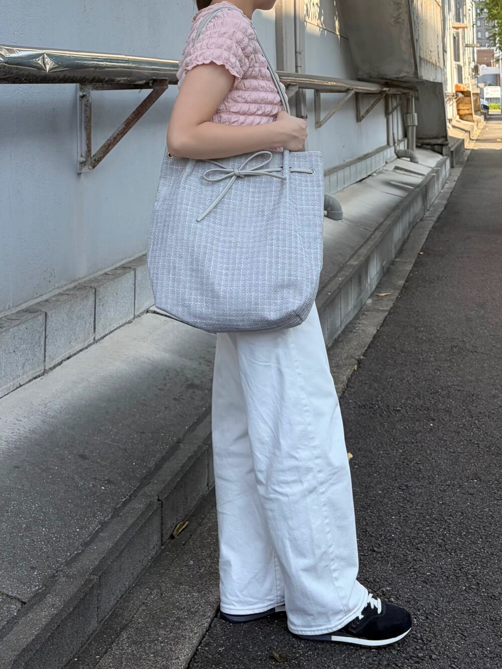 グレー系のトートバッグを着用したレディースの夏コーディネートの2枚目の写真