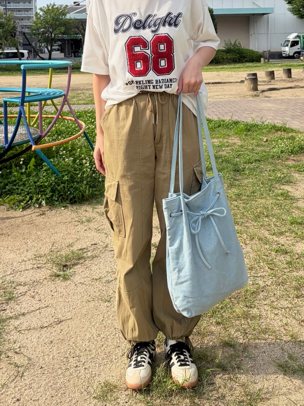 ブルー系のトートバッグを着用したレディースの夏コーディネートの2枚目の写真