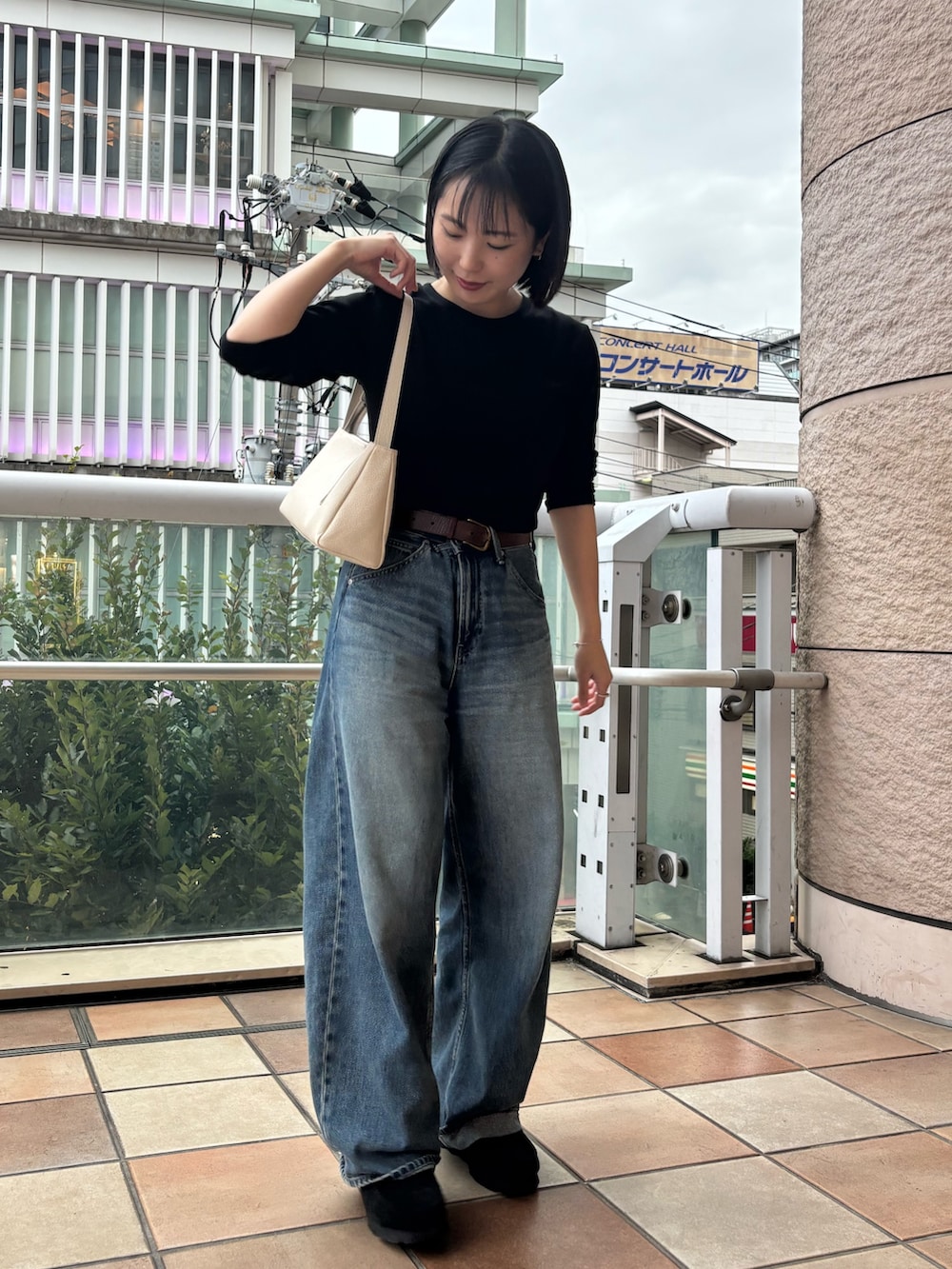 ホワイト系のショルダーバッグを着用したレディースの秋コーディネートの2枚目の写真