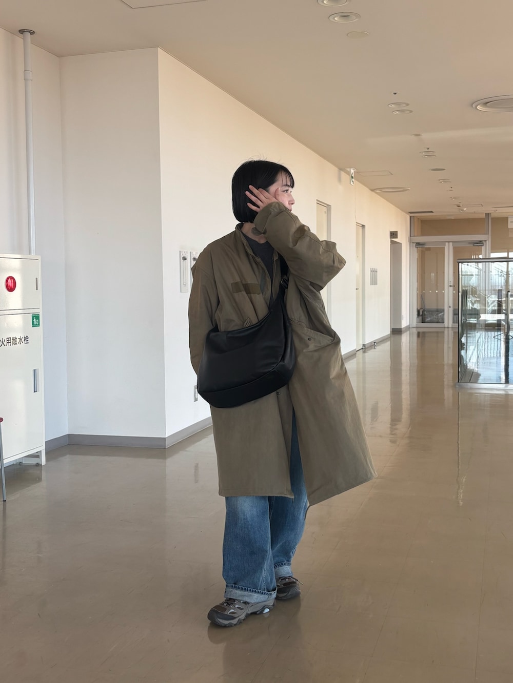 ブラック系のショルダーバッグを着用したレディースの冬コーディネートの2枚目の写真