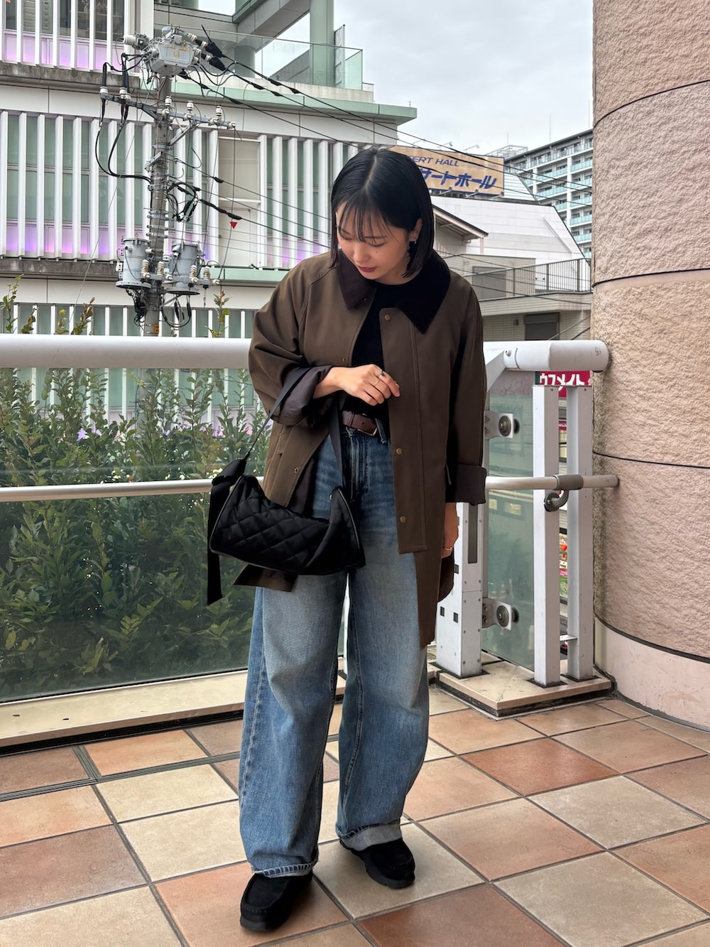 ブラック系のショルダーバッグを着用したレディースの秋コーディネートの2枚目の写真