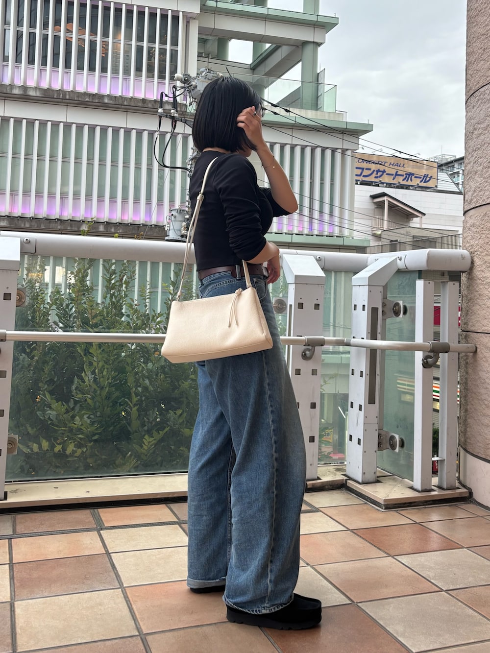 ホワイト系のショルダーバッグを着用したレディースの秋コーディネートの3枚目の写真