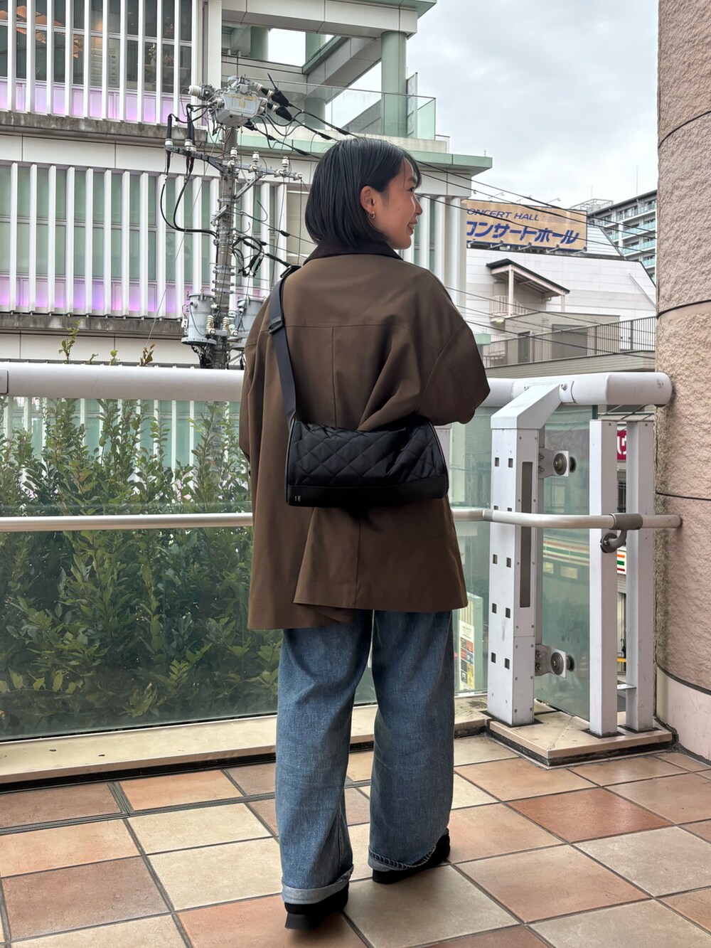 ブラック系のショルダーバッグを着用したレディースの秋コーディネートの3枚目の写真