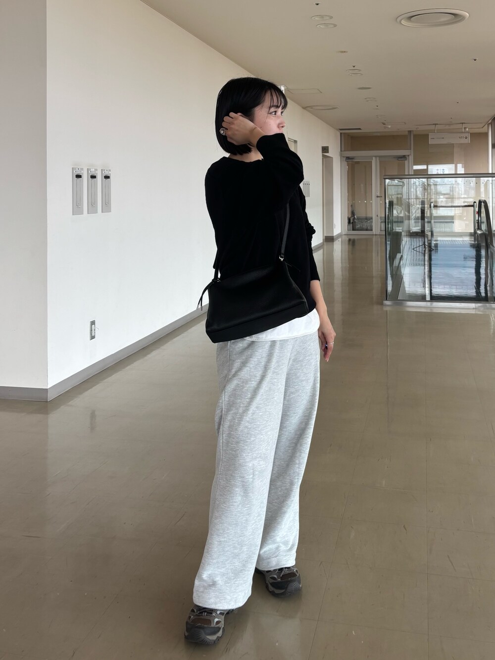 ブラック系のショルダーバッグを着用したレディースの秋コーディネートの2枚目の写真