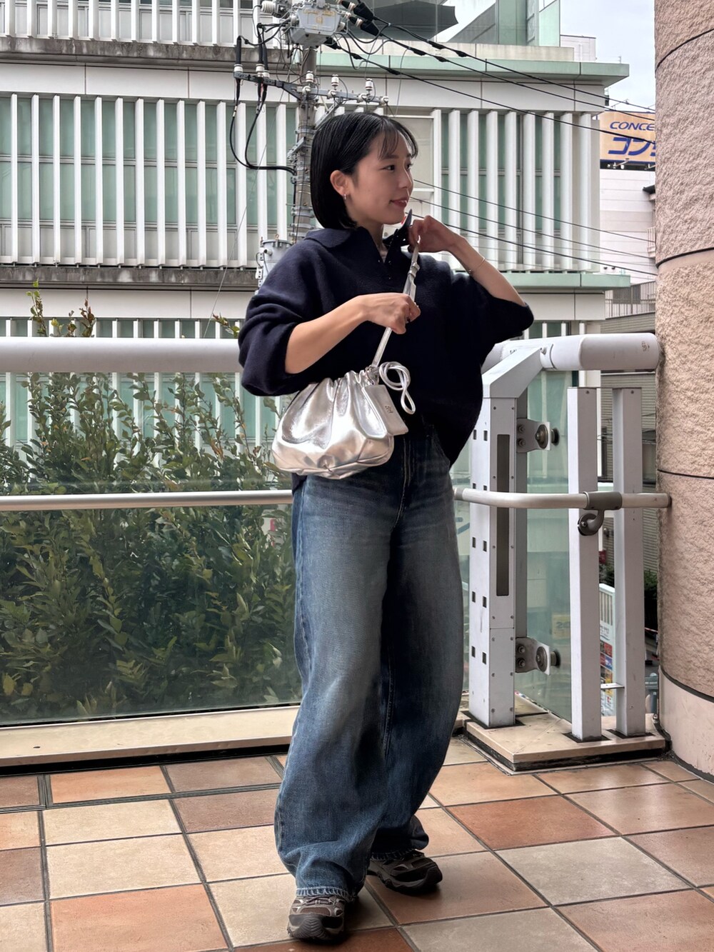 シルバー系のショルダーバッグ、シルバー系のその他小物を着用したレディースの秋コーディネートの2枚目の写真