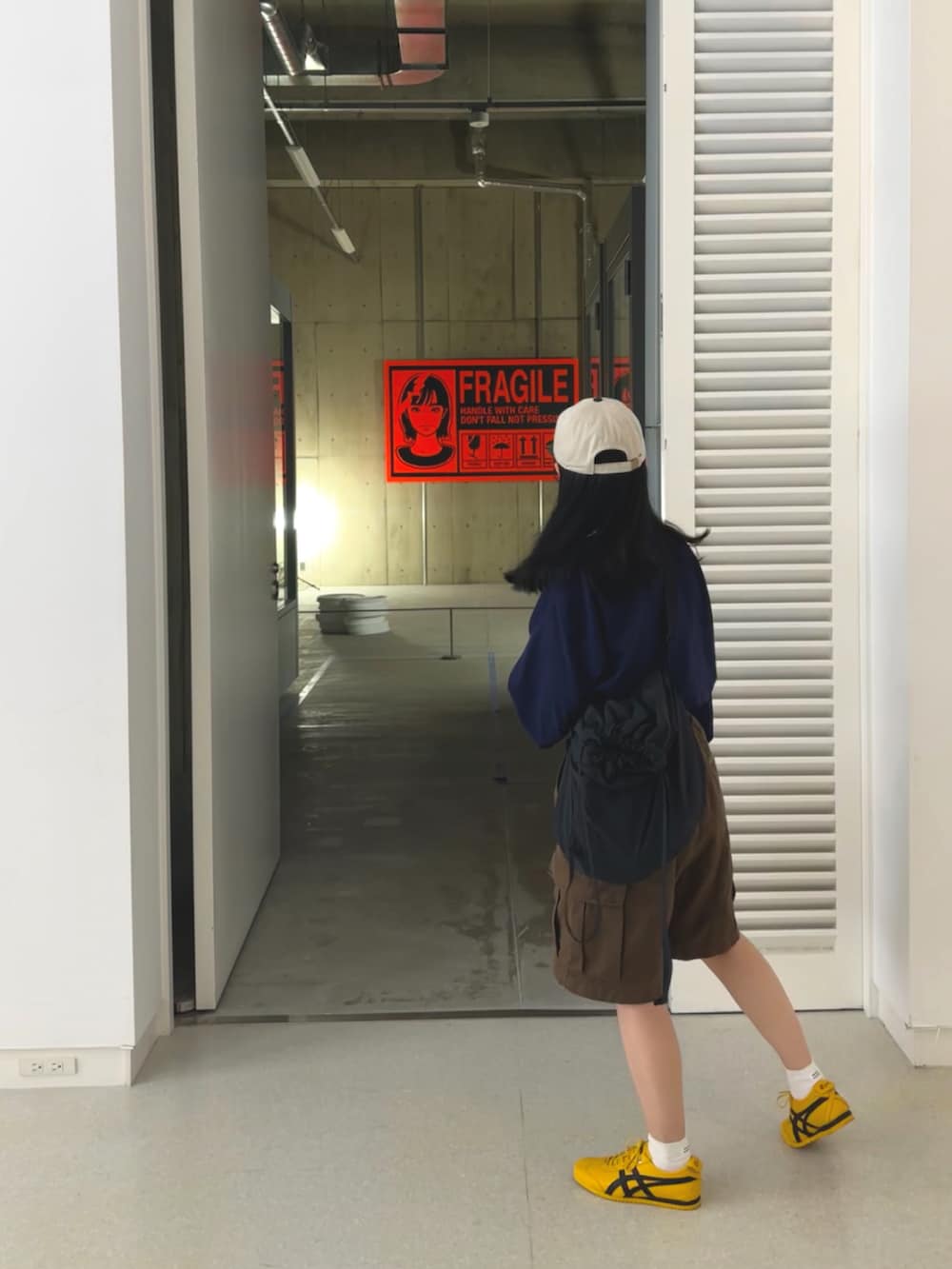 イエロー系のスニーカー、ブラウン系のその他パンツ、ブラック系のショルダーバッグを着用したレディースの春コーディネートの2枚目の写真