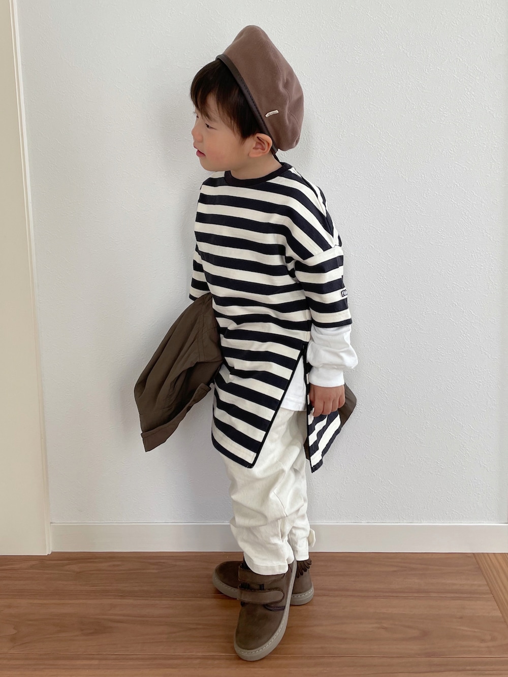 ブラウン系のジャケット/アウター、ブラック系のトップス、ベージュ系のパンツを着用したキッズの冬コーディネートの3枚目の写真