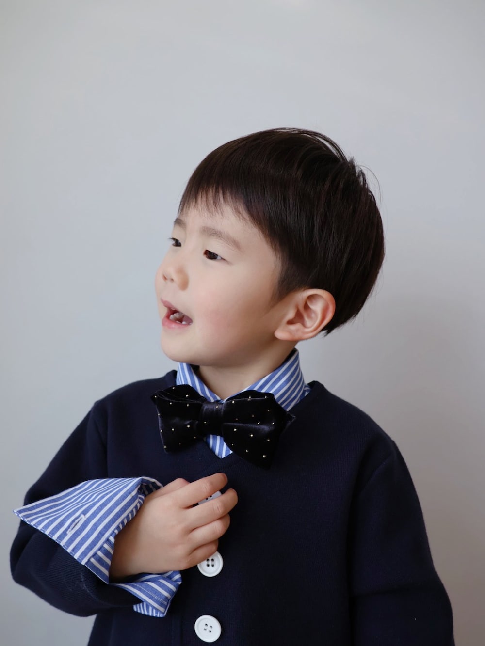 ブルー系のノーカラージャケット、ブルー系のシャツ/ブラウス、ブラック系のチノパンツを着用したキッズの冬コーディネートの3枚目の写真