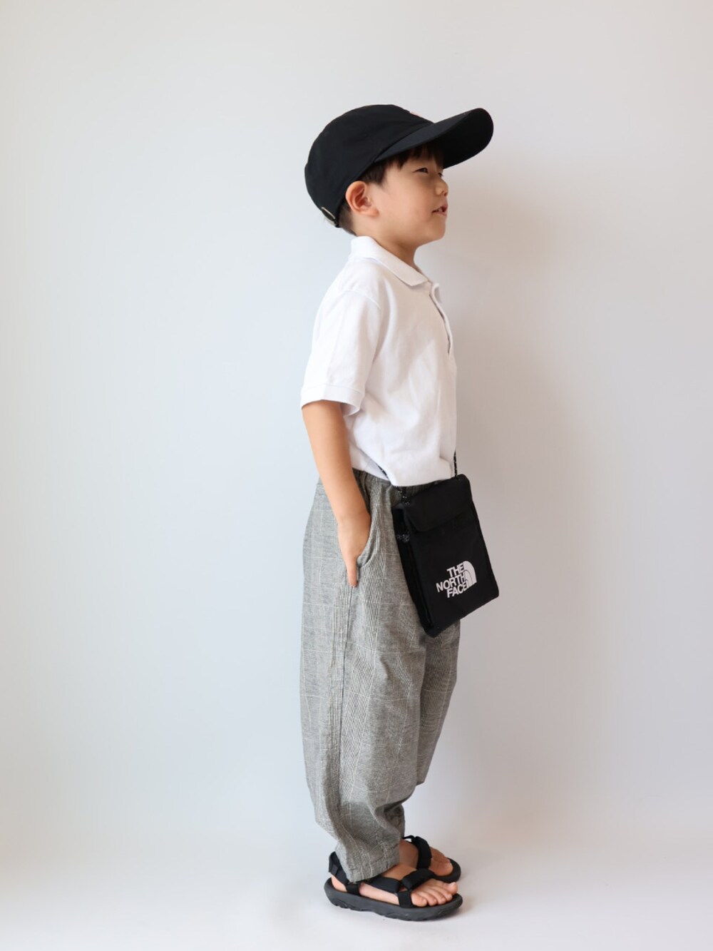その他のその他パンツ、ブラック系のサンダル、ブラック系のキャップを着用したキッズの夏コーディネートの3枚目の写真