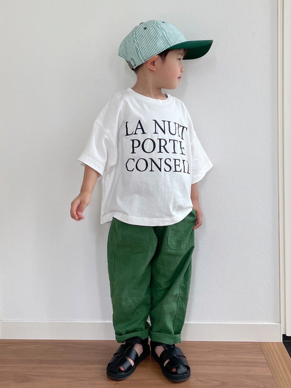 ホワイト系のTシャツ/カットソー、グリーン系のその他パンツ、ブラック系のサンダルを着用したキッズの夏コーディネートの2枚目の写真