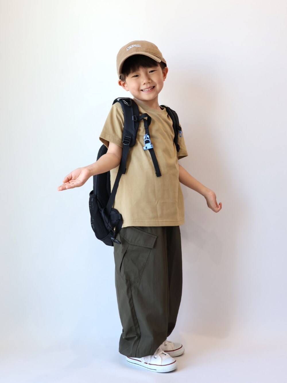 ベージュ系のTシャツ/カットソー、グリーン系のカーゴパンツ、ホワイト系のスニーカーを着用したキッズの夏コーディネートの2枚目の写真