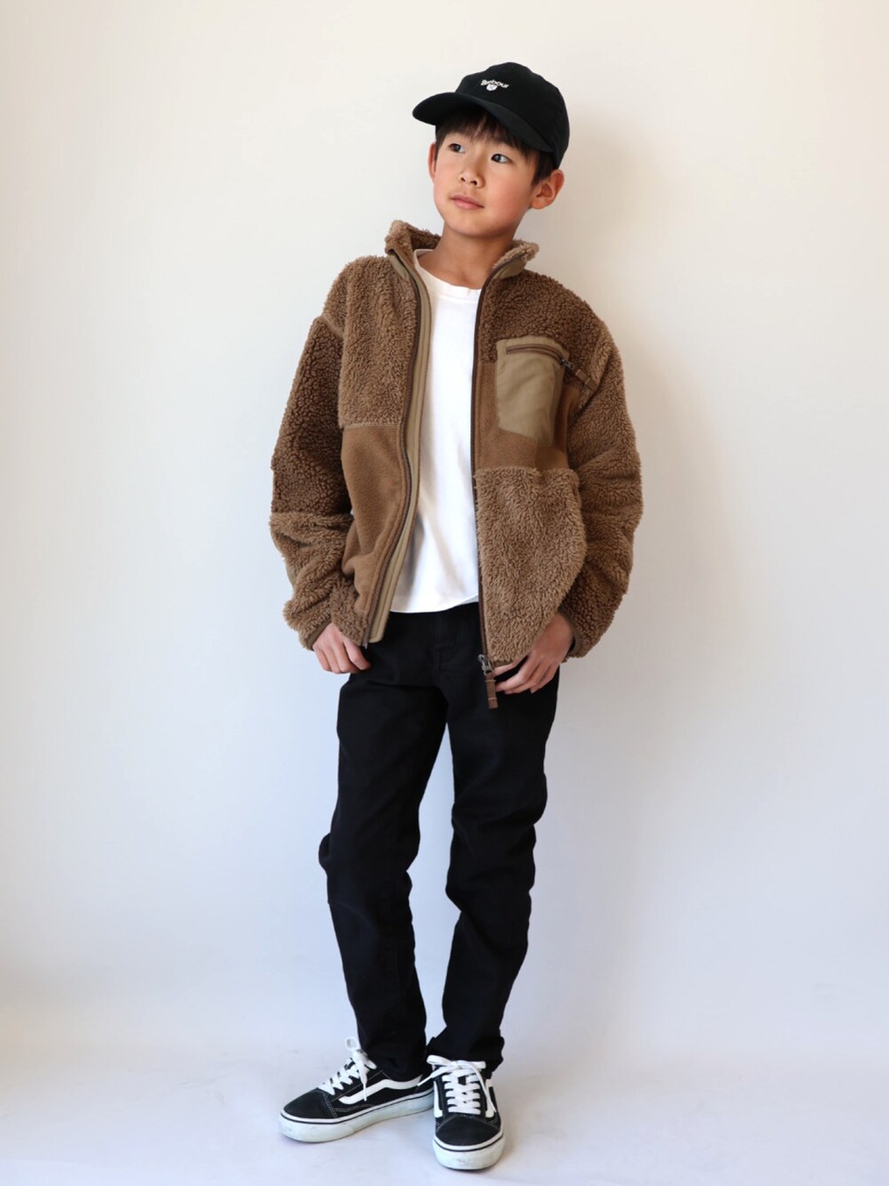 ホワイト系のTシャツ/カットソー、ベージュ系のジャケット/アウター、ブラック系のパンツを着用したキッズの冬コーディネートの2枚目の写真