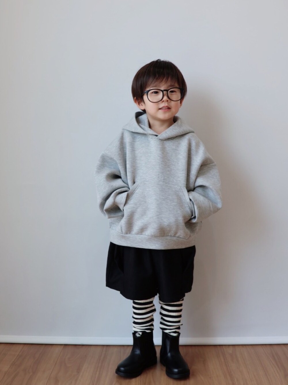 グレー系のパーカー、ブラック系のその他パンツ、ブラック系のブーツを着用したキッズの冬コーディネートの2枚目の写真