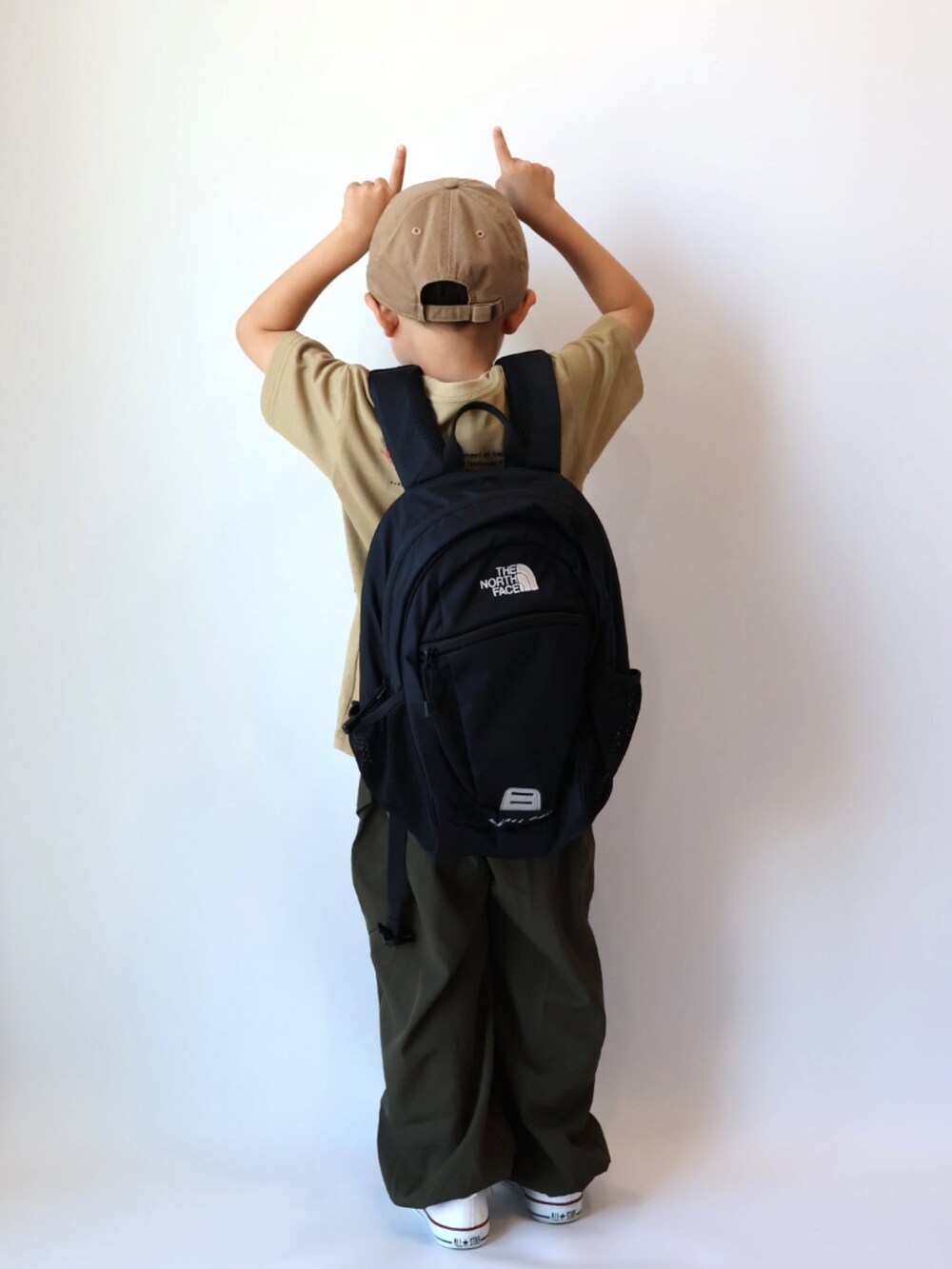 ベージュ系のTシャツ/カットソー、グリーン系のカーゴパンツ、ホワイト系のスニーカーを着用したキッズの夏コーディネートの4枚目の写真