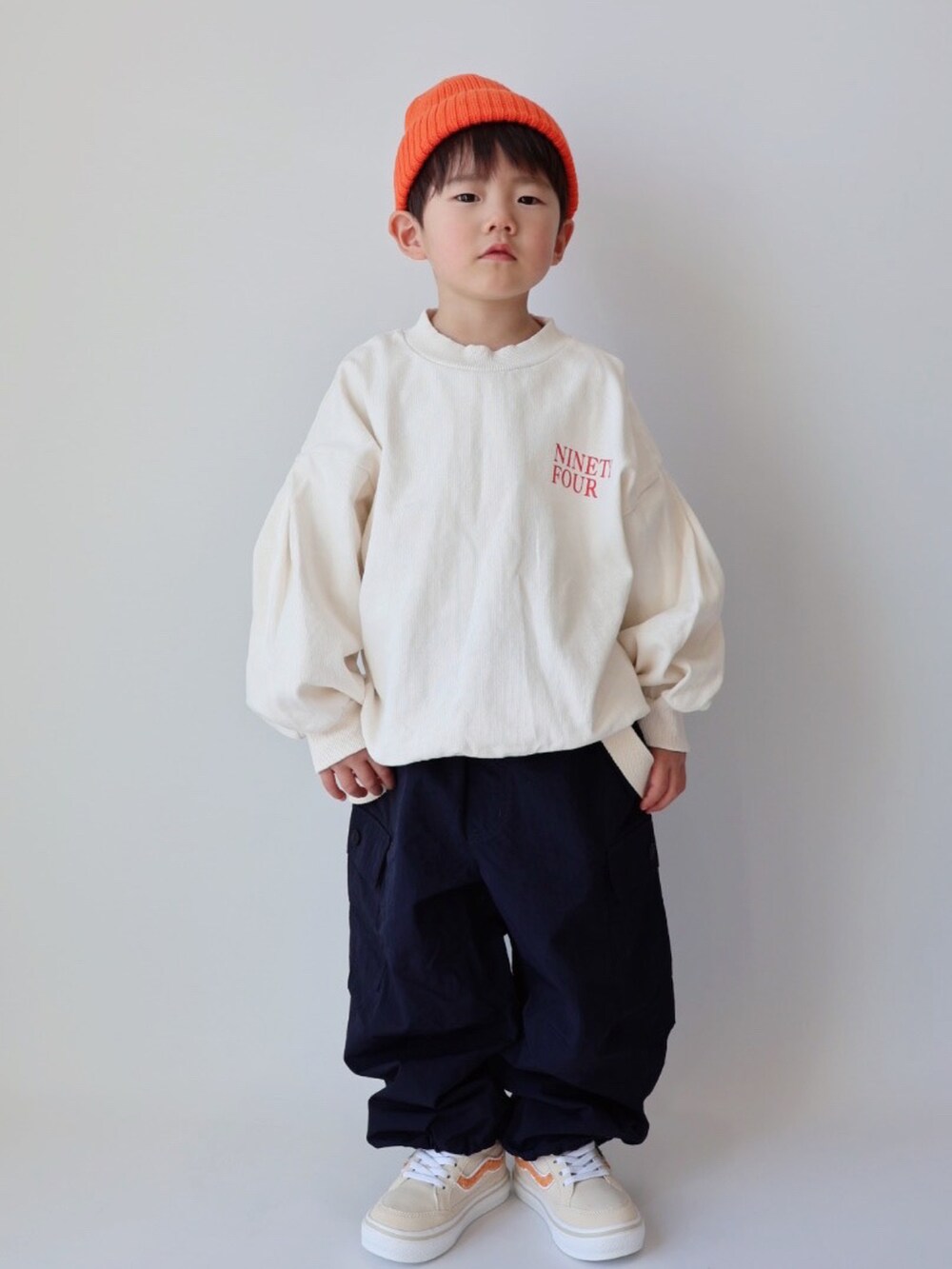 ホワイト系のスウェット、ブルー系のカーゴパンツ、ベージュ系のスニーカーを着用したキッズの冬コーディネートの2枚目の写真