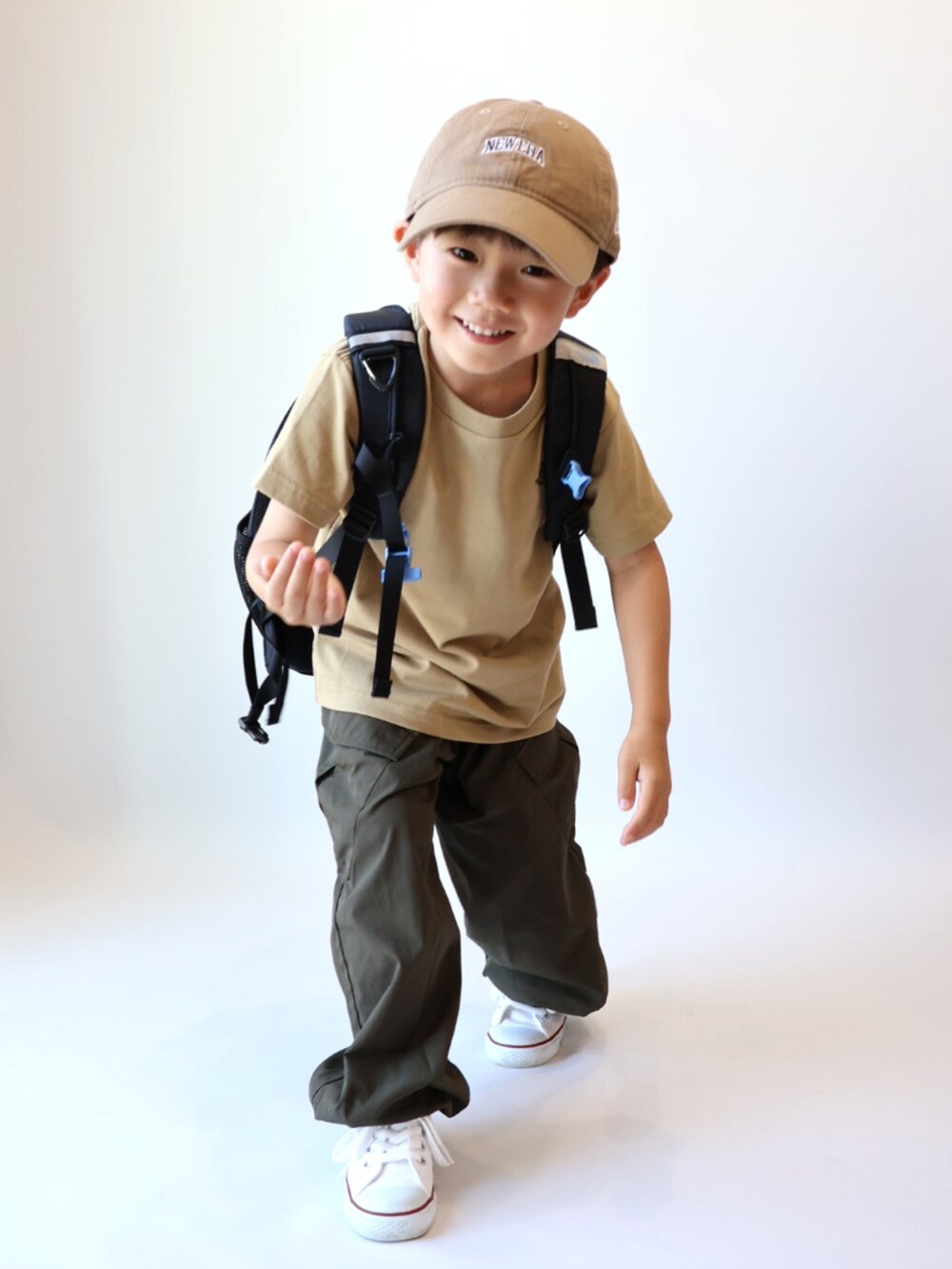 ベージュ系のTシャツ/カットソー、グリーン系のカーゴパンツ、ホワイト系のスニーカーを着用したキッズの夏コーディネートの5枚目の写真