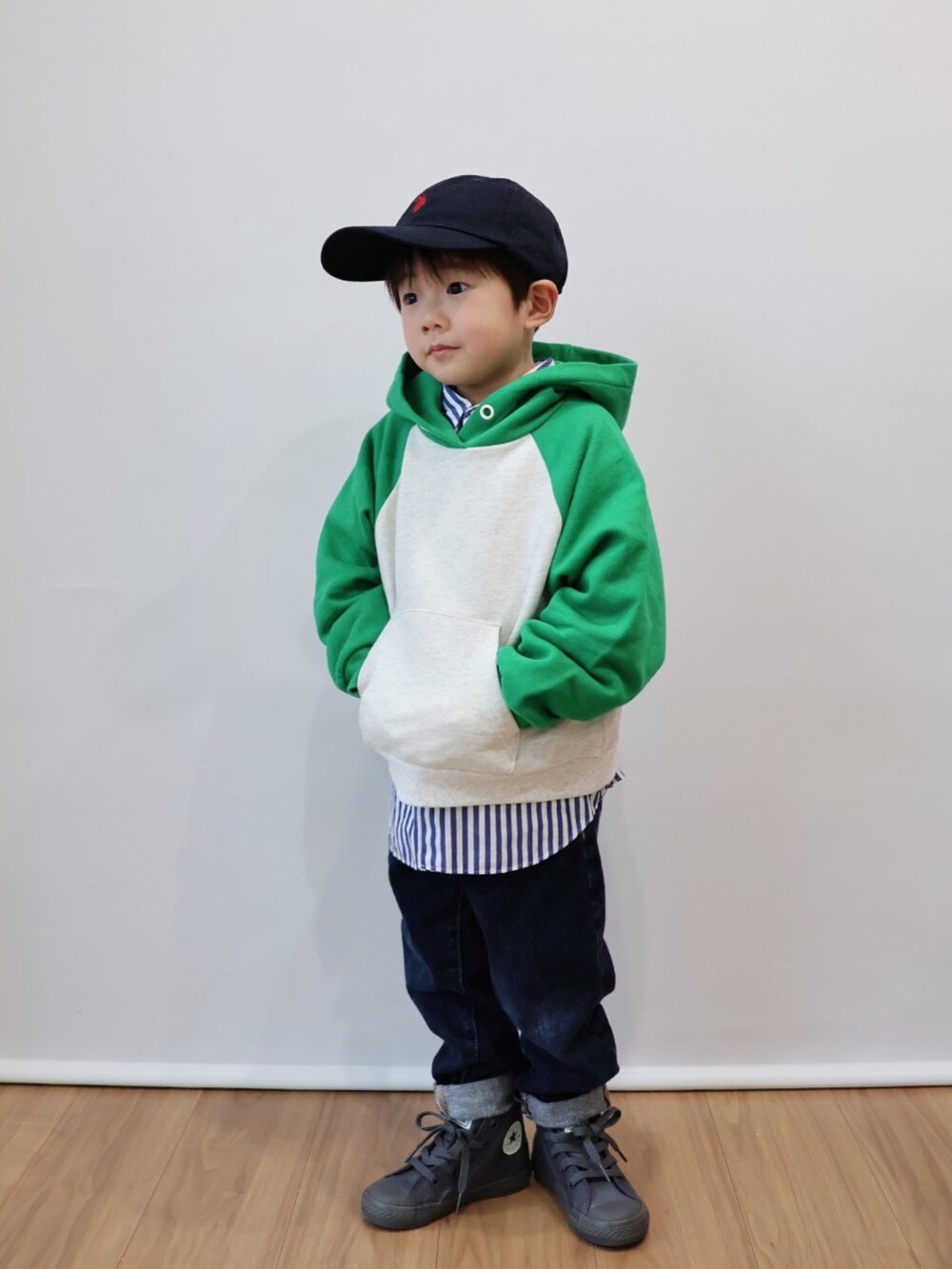 グリーン系のパーカー、ブルー系のシャツ/ブラウス、ブルー系のデニムパンツを着用したキッズの冬コーディネートの2枚目の写真