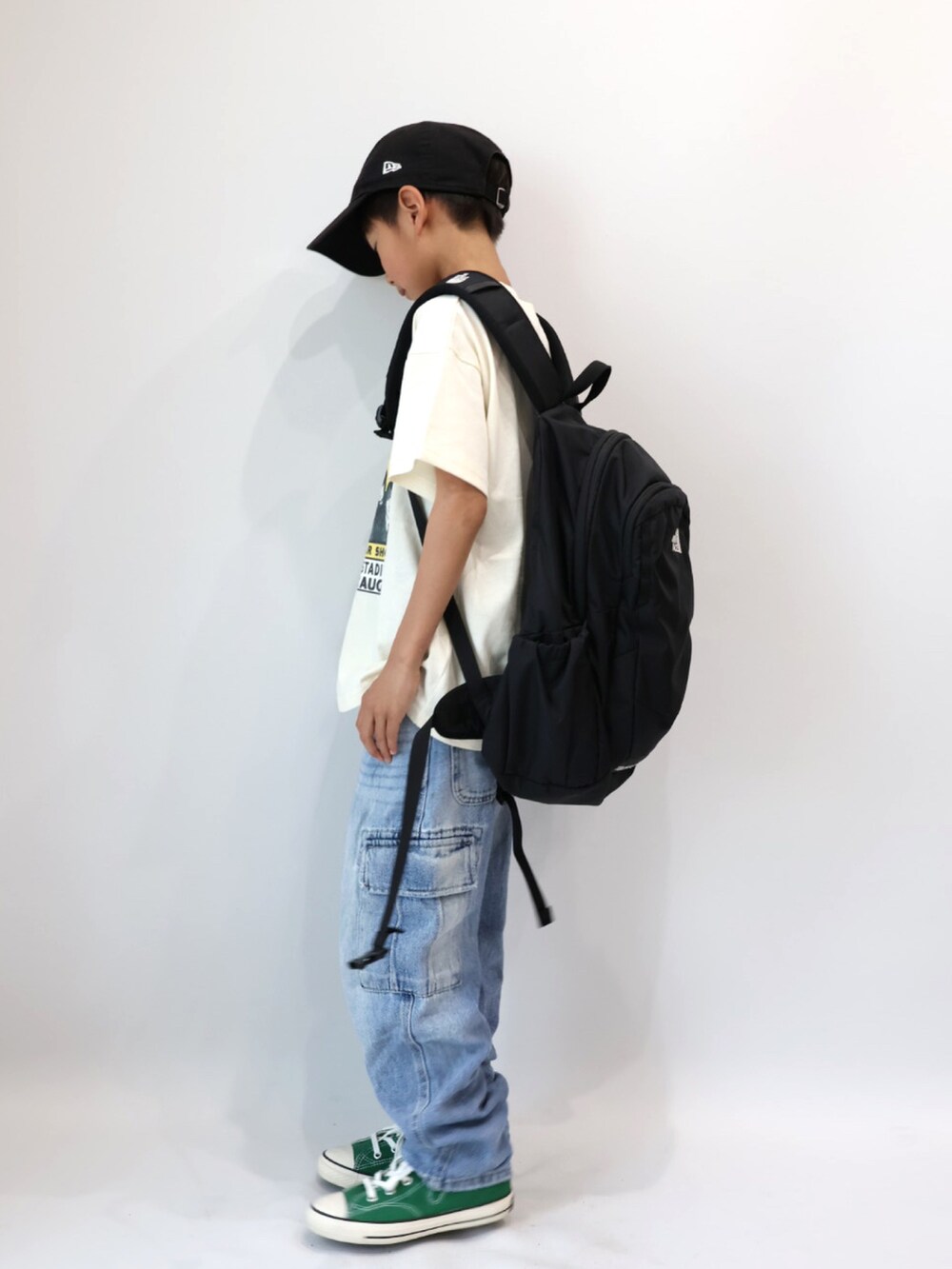 ホワイト系のTシャツ/カットソー、ブルー系のデニムパンツ、グリーン系のスニーカーを着用したキッズの春コーディネートの3枚目の写真