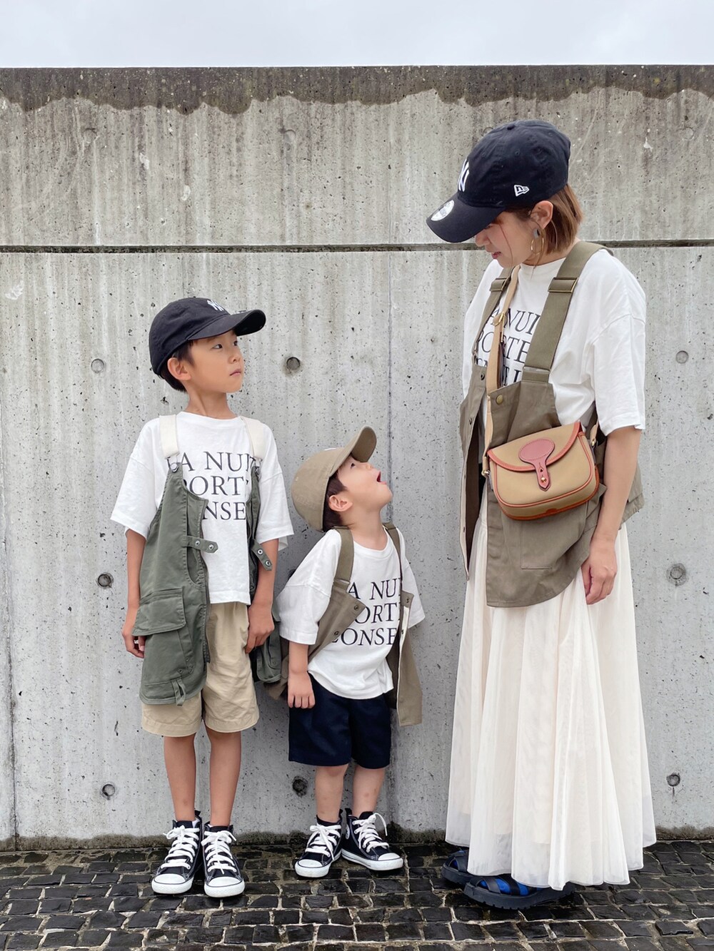 グリーン系のベスト、ホワイト系のTシャツ/カットソー、ブラック系のスニーカーを着用したキッズの夏コーディネートの3枚目の写真