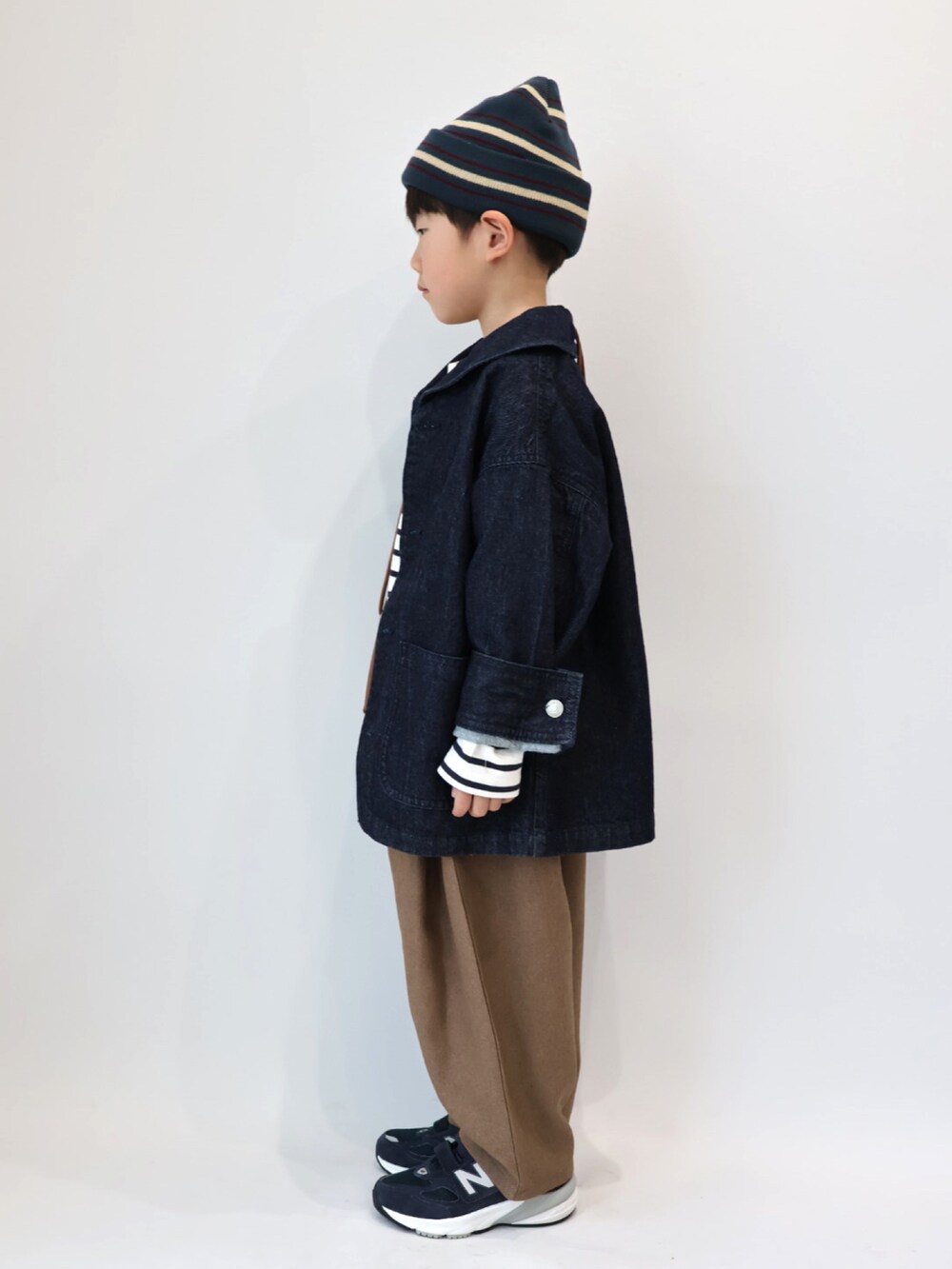 ブルー系のカバーオール、ブラウン系のショルダーバッグ、その他のトップスを着用したキッズの冬コーディネートの3枚目の写真