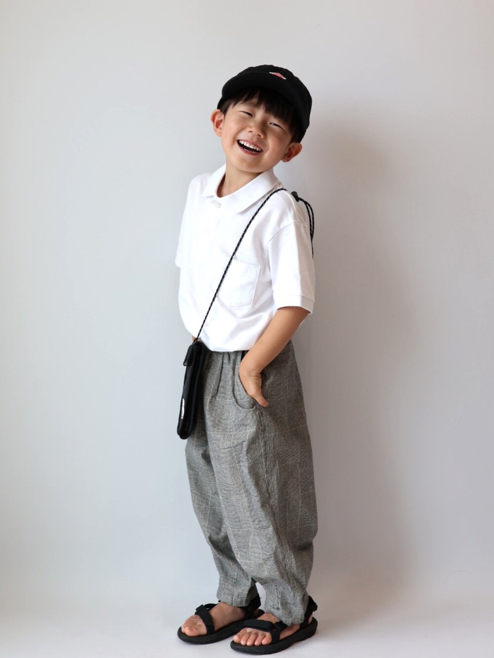 その他のその他パンツ、ブラック系のサンダル、ブラック系のキャップを着用したキッズの夏コーディネートの2枚目の写真