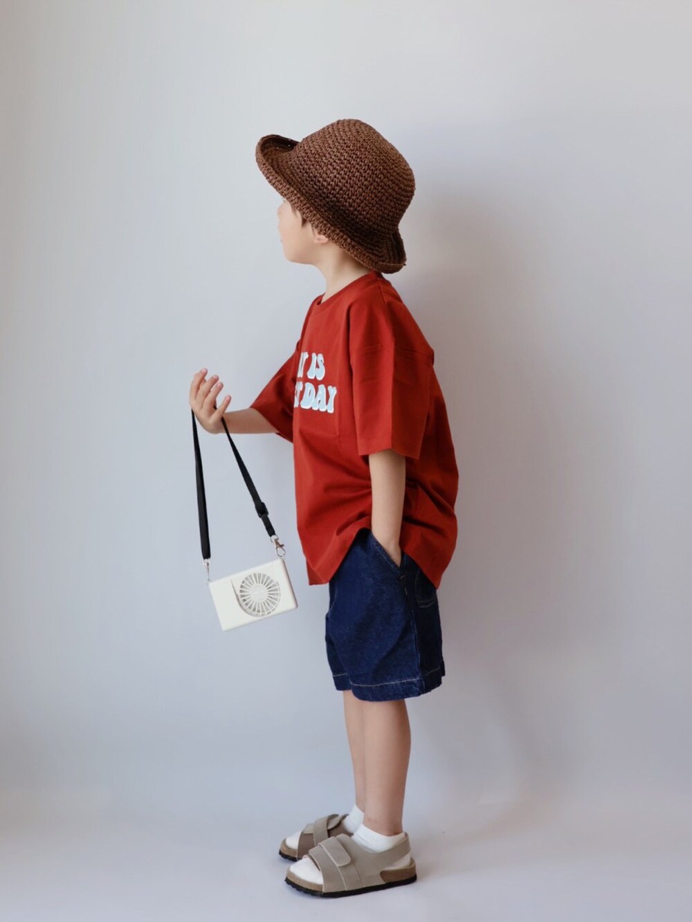 レッド系のTシャツ/カットソー、ブルー系のパンツ、ベージュ系のサンダルを着用したキッズの夏コーディネートの3枚目の写真