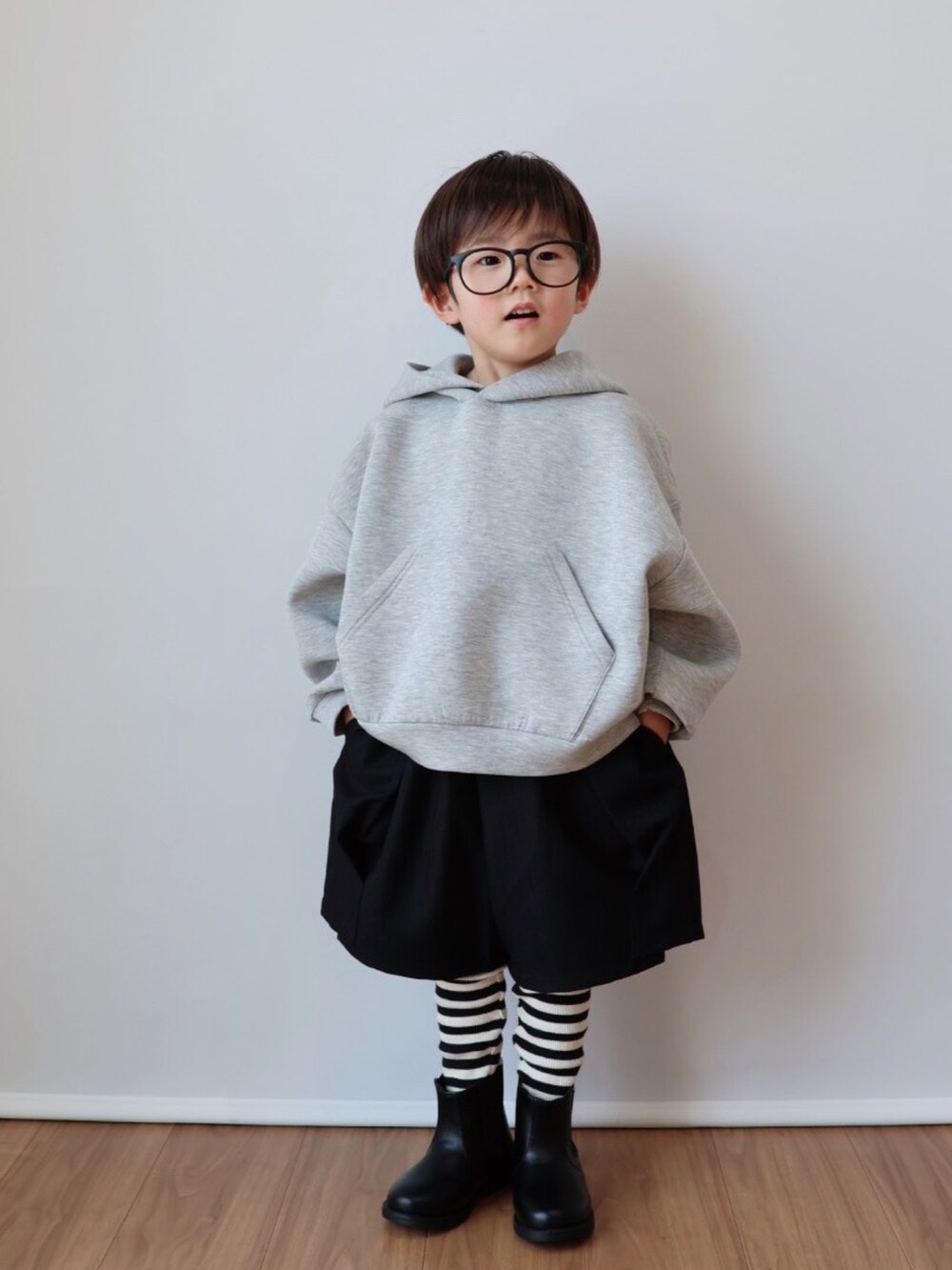 グレー系のパーカー、ブラック系のその他パンツ、ブラック系のブーツを着用したキッズの冬コーディネートの3枚目の写真