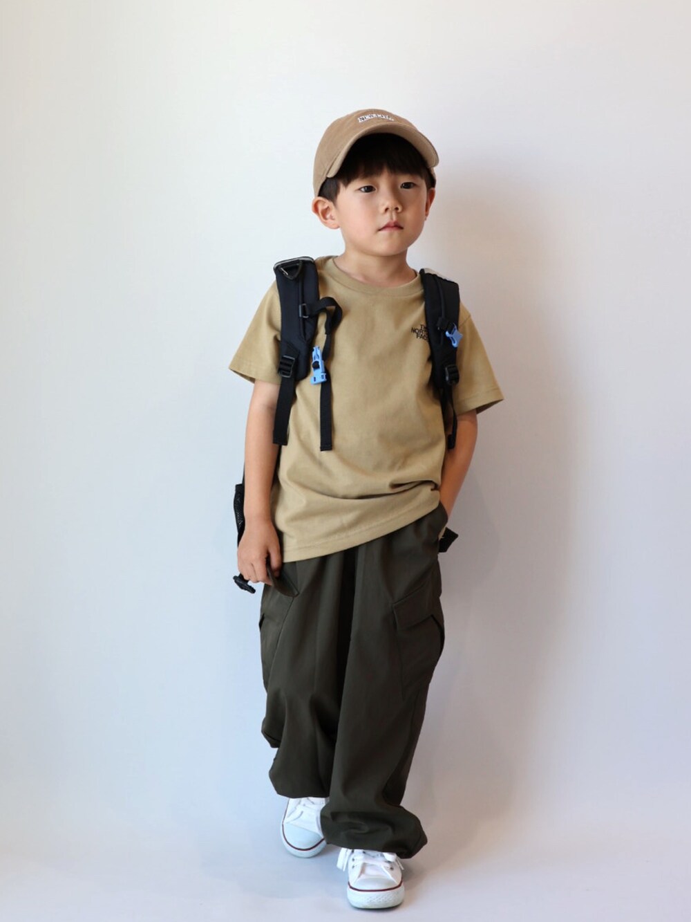ベージュ系のTシャツ/カットソー、グリーン系のカーゴパンツ、ホワイト系のスニーカーを着用したキッズの夏コーディネートの3枚目の写真