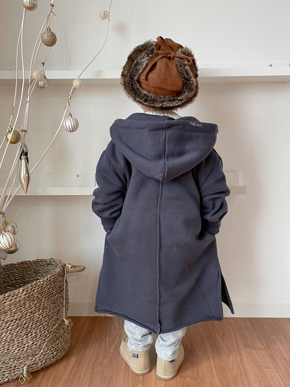 ホワイト系のニット/セーター、グレー系のパーカー、グレー系のスウェットパンツを着用したキッズの冬コーディネートの2枚目の写真