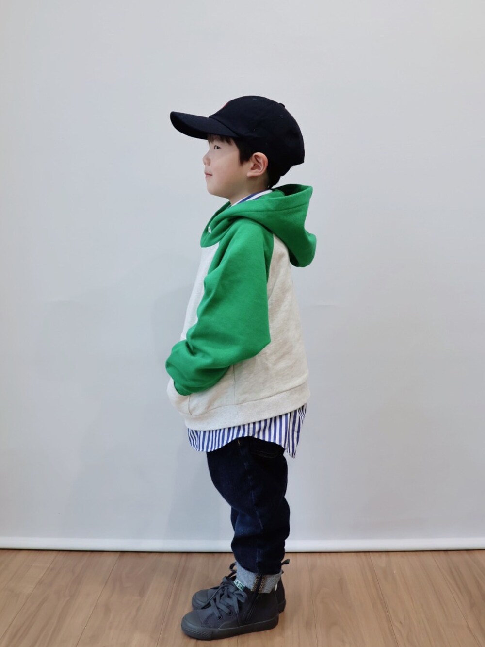 グリーン系のパーカー、ブルー系のシャツ/ブラウス、ブルー系のデニムパンツを着用したキッズの冬コーディネートの3枚目の写真