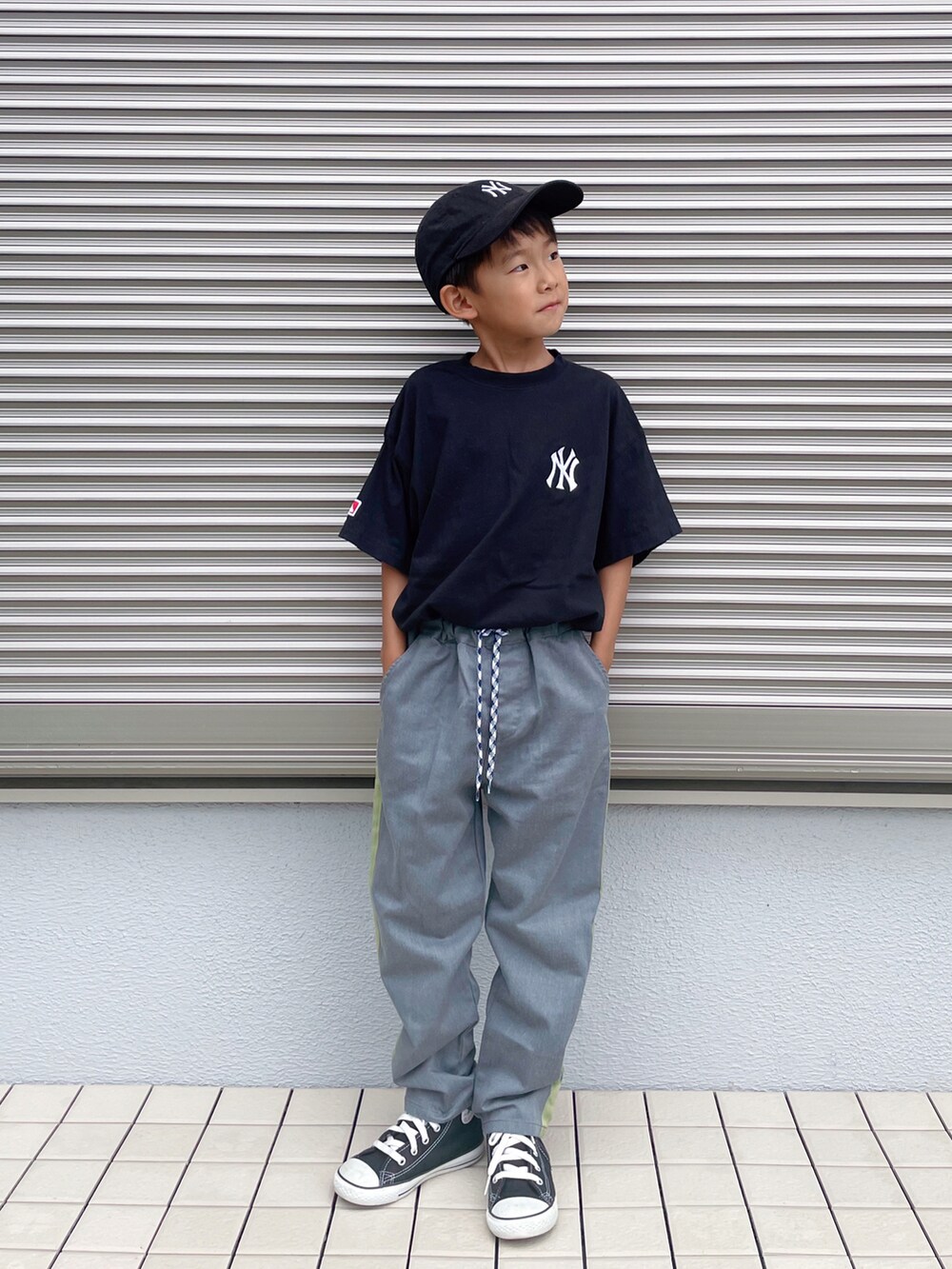 グレー系のパンツ、ブラック系のスニーカー、ブラック系のキャップを着用したキッズの夏コーディネートの2枚目の写真