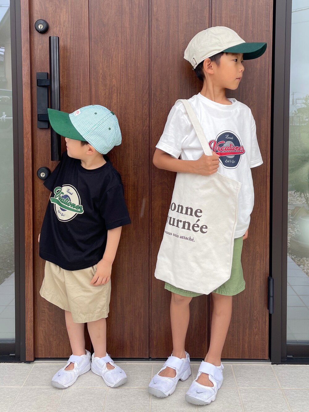 ブラック系のトップス、ベージュ系のパンツ、ホワイト系のスニーカーを着用したキッズの夏コーディネートの2枚目の写真