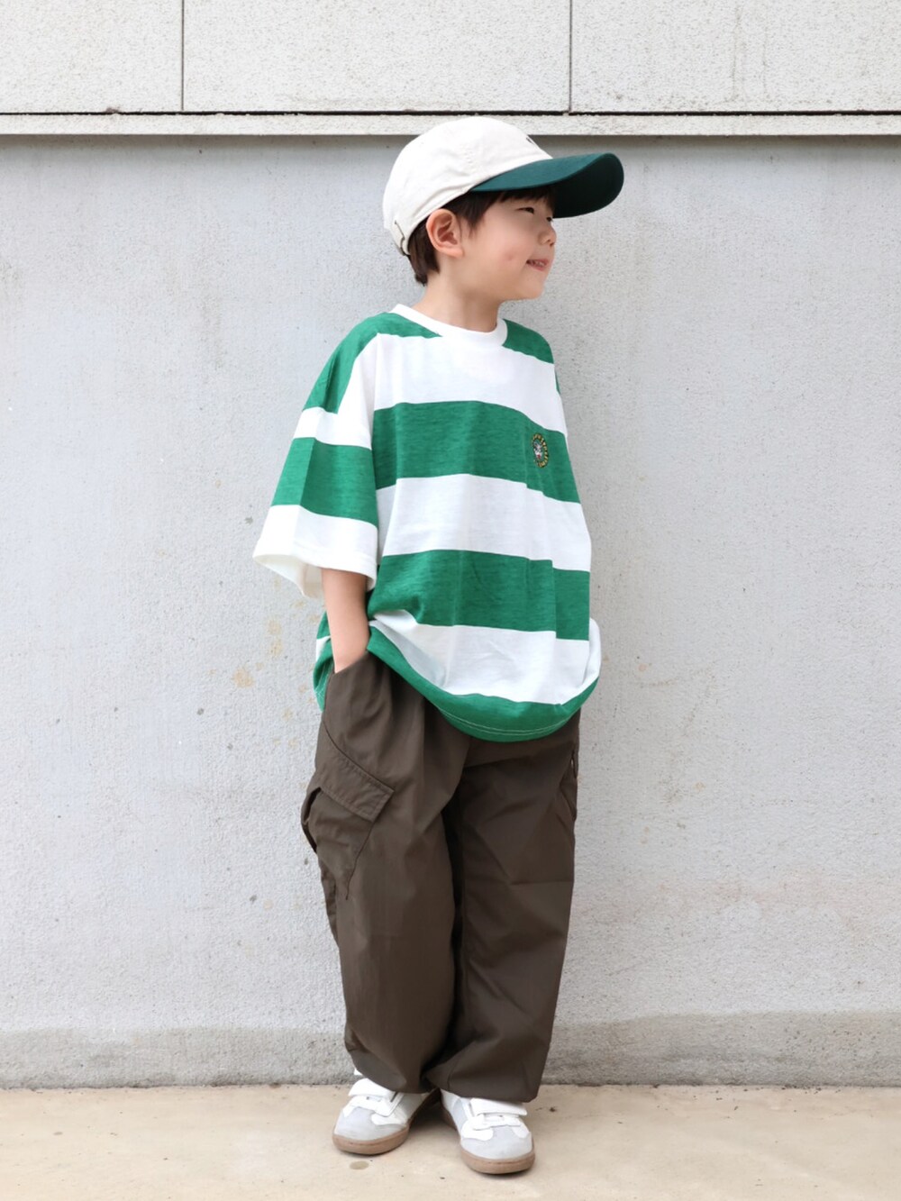 グリーン系のTシャツ/カットソー、グリーン系のカーゴパンツ、ホワイト系のシューズを着用したキッズの春コーディネートの2枚目の写真
