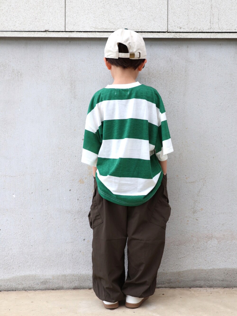 グリーン系のTシャツ/カットソー、グリーン系のカーゴパンツ、ホワイト系のシューズを着用したキッズの春コーディネートの4枚目の写真