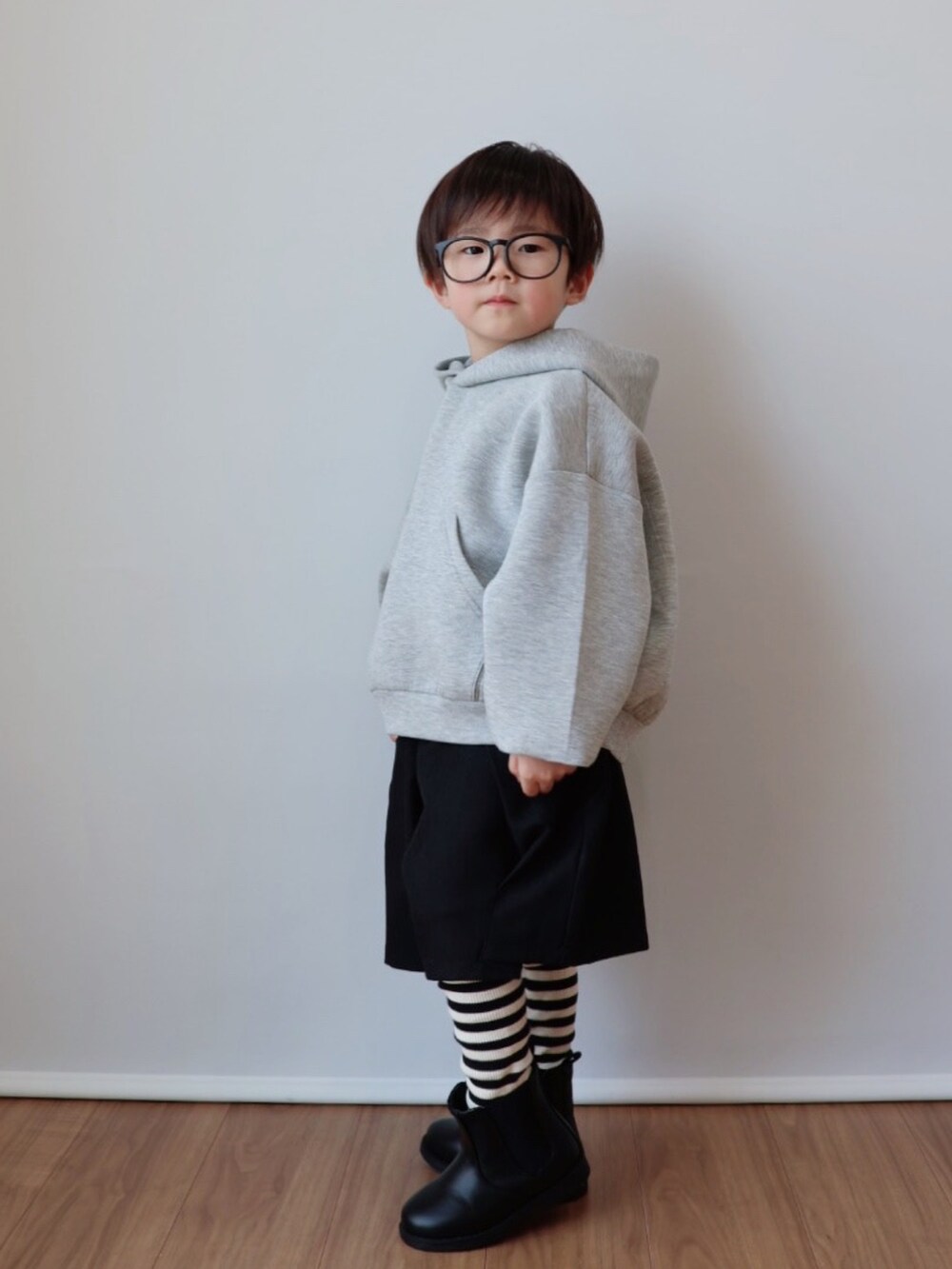 グレー系のパーカー、ブラック系のその他パンツ、ブラック系のブーツを着用したキッズの冬コーディネートの4枚目の写真