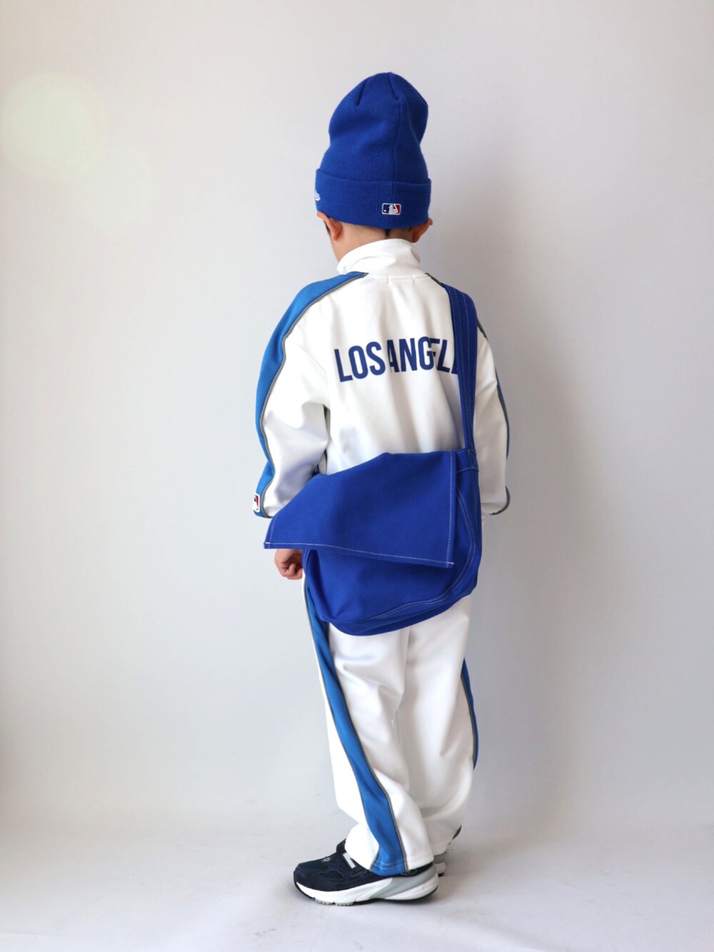 ベージュ系のジャージ、ベージュ系のスウェットパンツ、ブルー系のショルダーバッグを着用したキッズの冬コーディネートの5枚目の写真