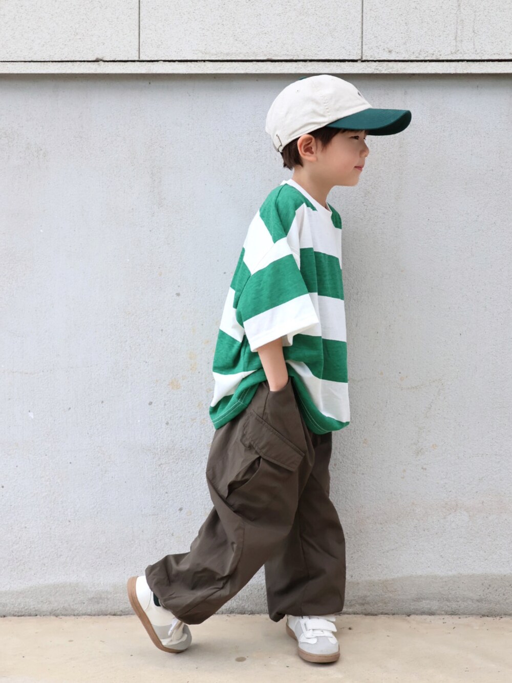 グリーン系のTシャツ/カットソー、グリーン系のカーゴパンツ、ホワイト系のシューズを着用したキッズの春コーディネートの3枚目の写真