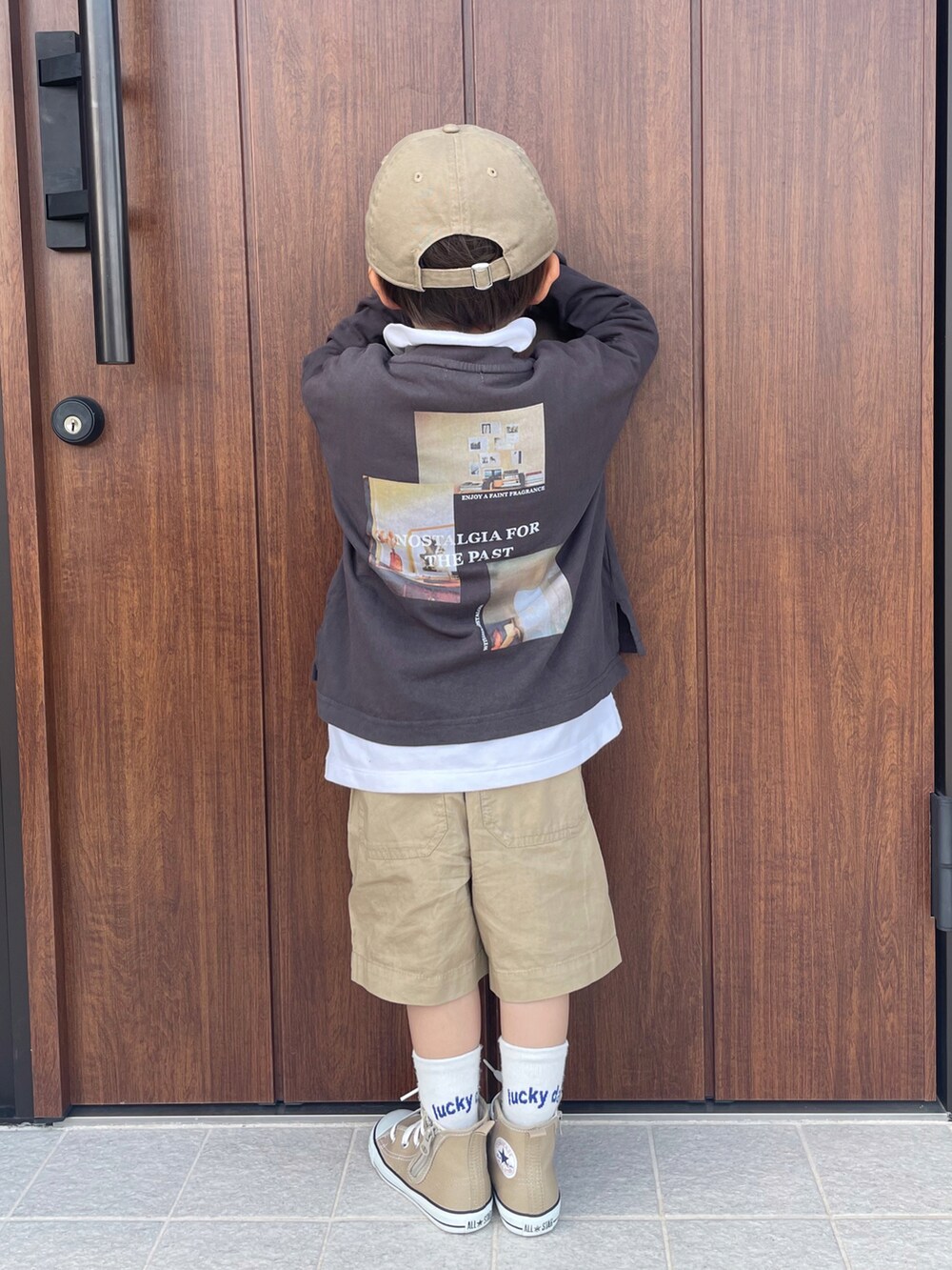 グレー系のTシャツ/カットソー、ホワイト系のトップス、ベージュ系のパンツを着用したキッズの春コーディネートの3枚目の写真