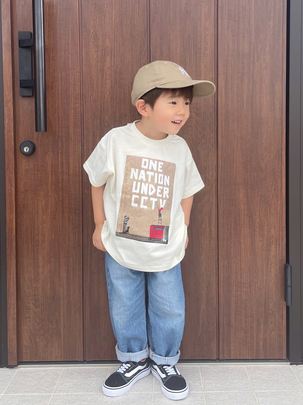 ブルー系のデニムパンツ、ブラック系のスニーカー、ベージュ系のキャップを着用したキッズの夏コーディネートの2枚目の写真