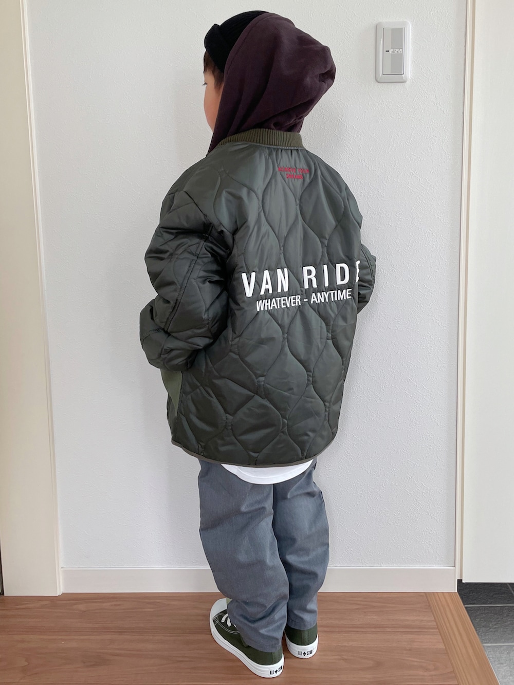 ブラウン系のパーカー、グリーン系のジャケット/アウター、ホワイト系のTシャツ/カットソーを着用したキッズの冬コーディネートの2枚目の写真