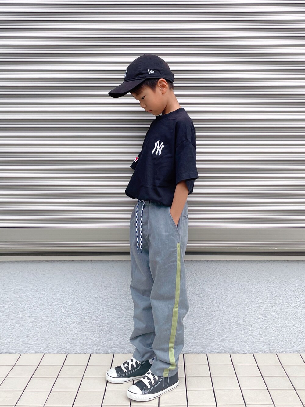 グレー系のパンツ、ブラック系のスニーカー、ブラック系のキャップを着用したキッズの夏コーディネートの3枚目の写真